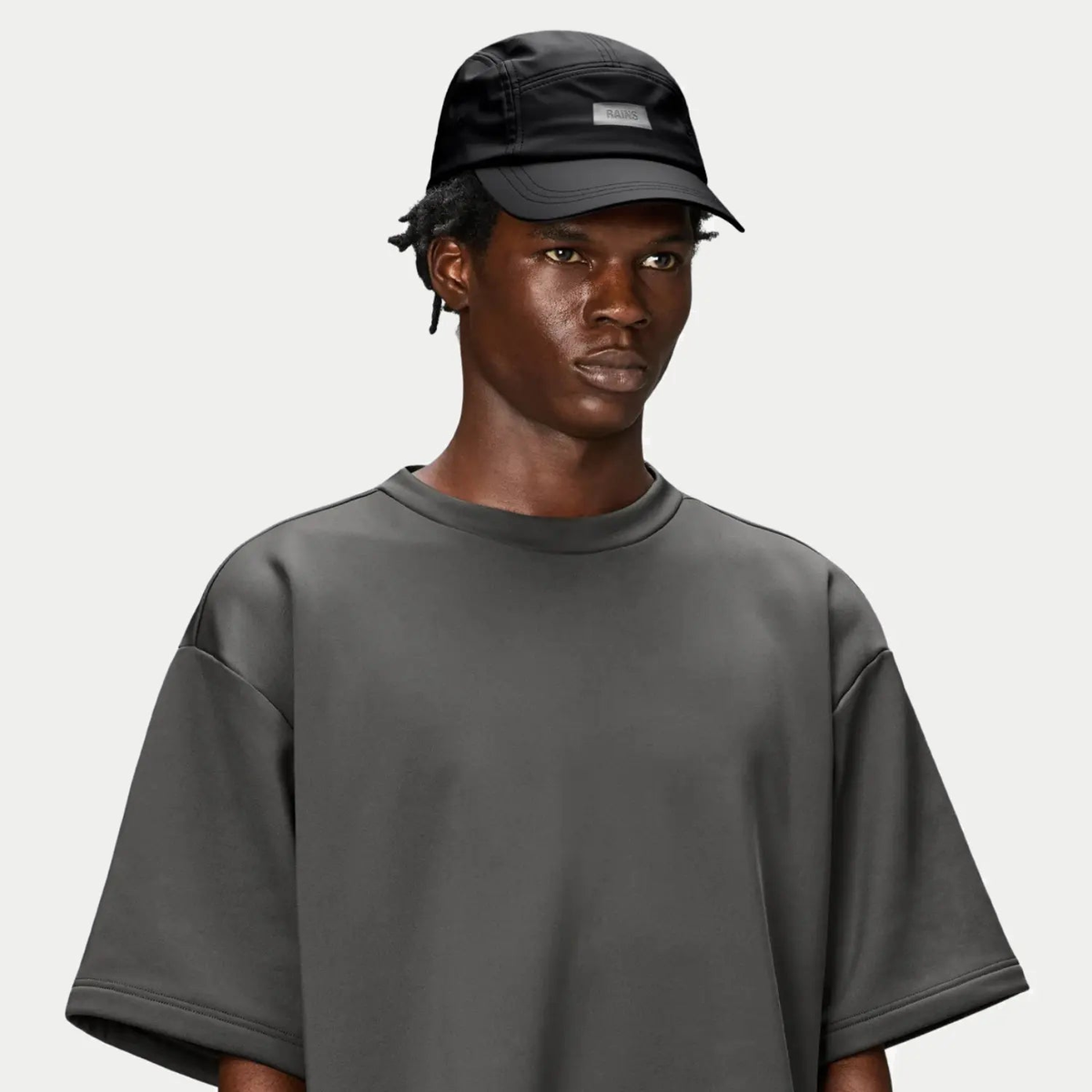 5 Panel Cap noire portée, calotte souple et étiquette grise sur le panneau avant