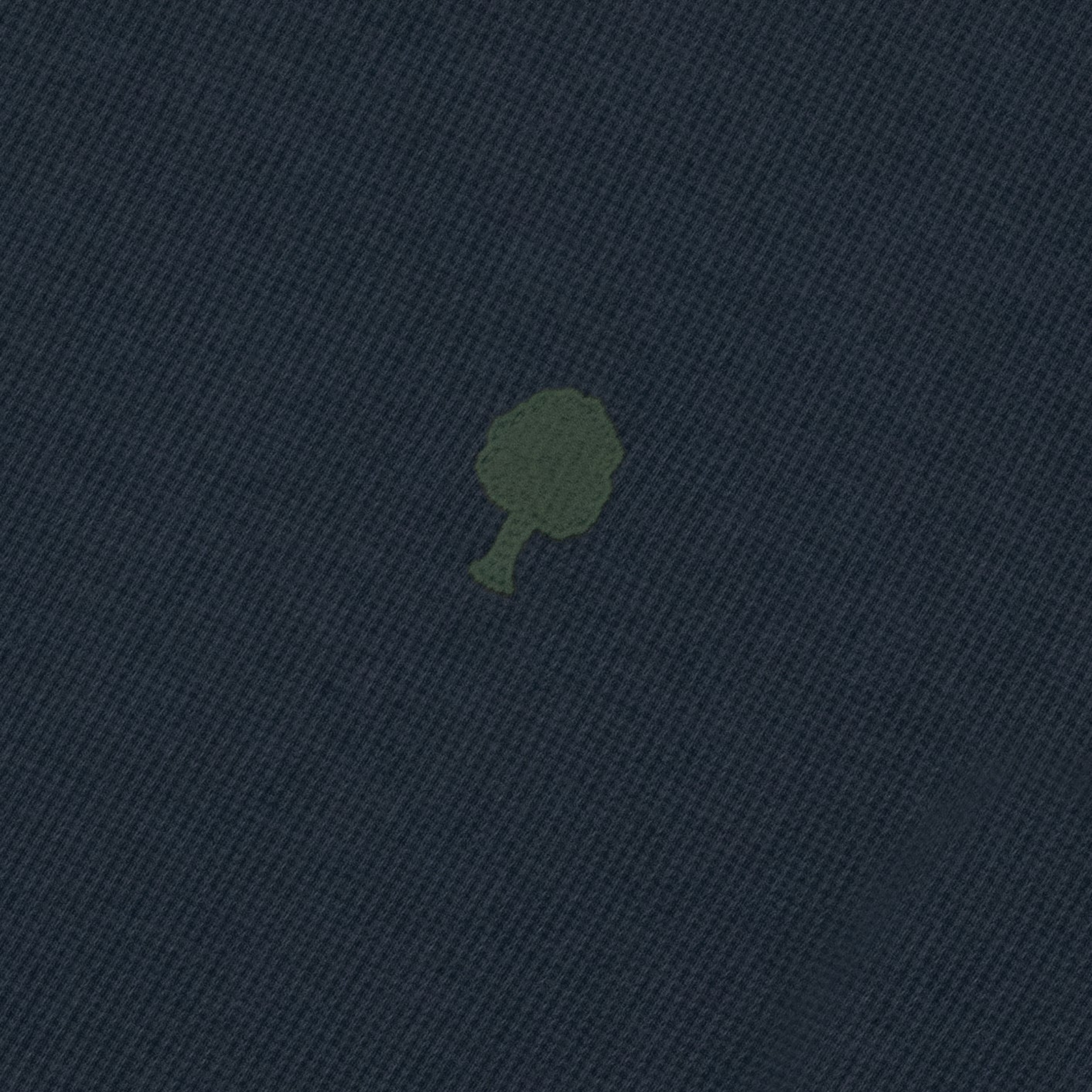 Détail de la maille piquée gaufrée bleu marine et de l'arbre brodé vert olive du t-shirt Bailly Faguo