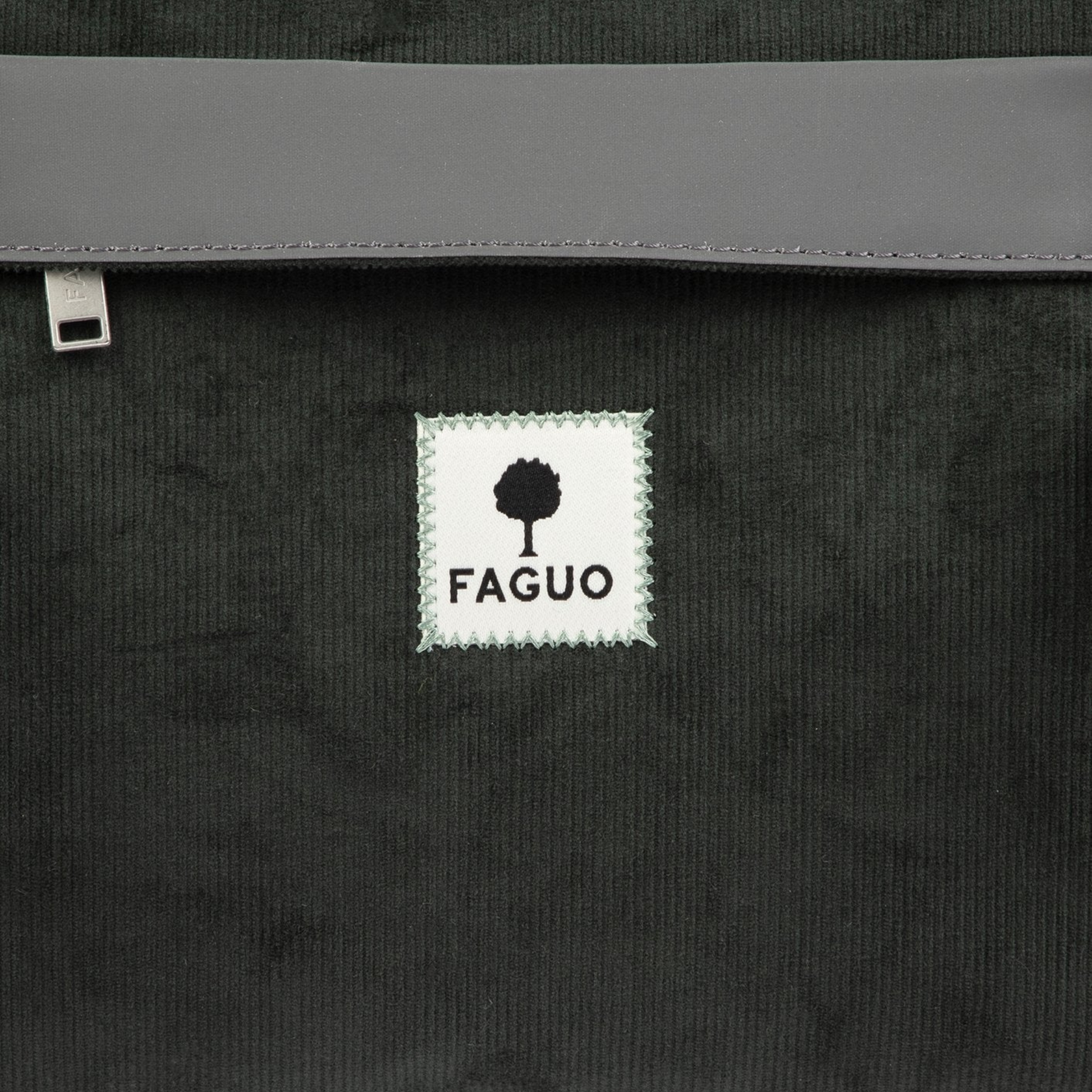 Détail du velours côtelé vert foncé du Big Duffle Faguo : étiquette tissée FAGUO et bande réfléchissante grise