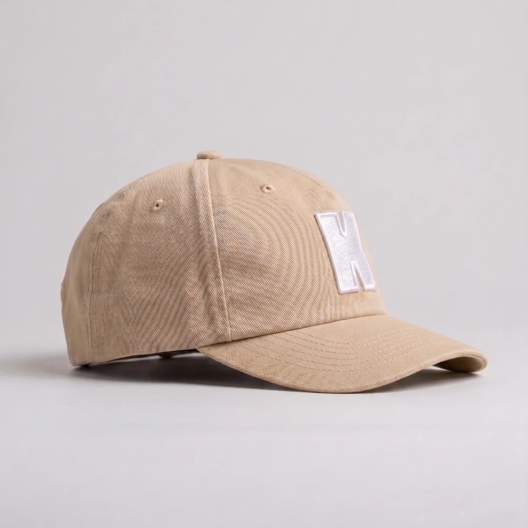 Casquette Klubb beige sable de trois quarts : sergé de coton, œillets d'aération et bouton de sommet assorti