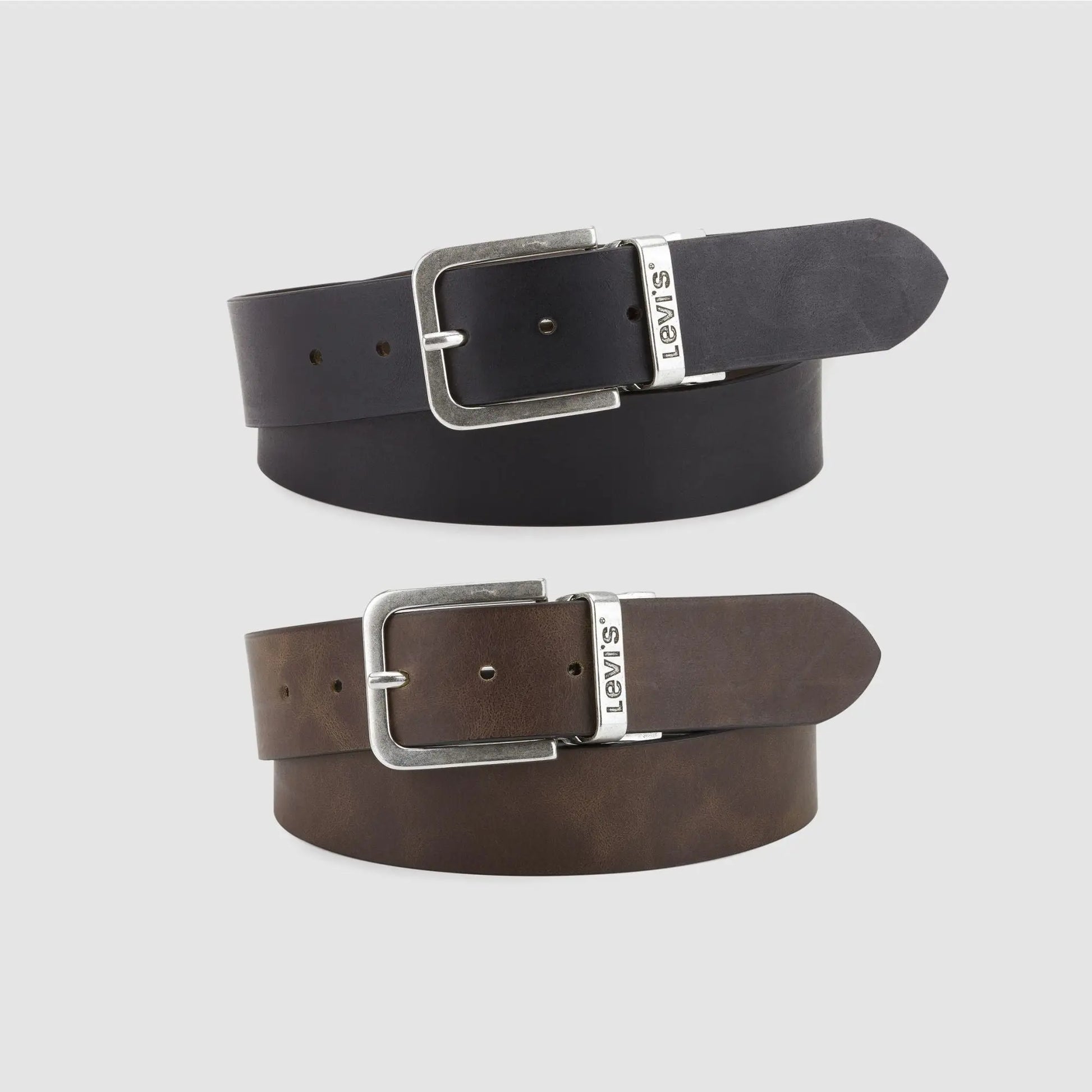 Ceinture Levi's Legacy réversible en cuir : face noire enroulée au-dessus de la face marron, boucle argent vieilli