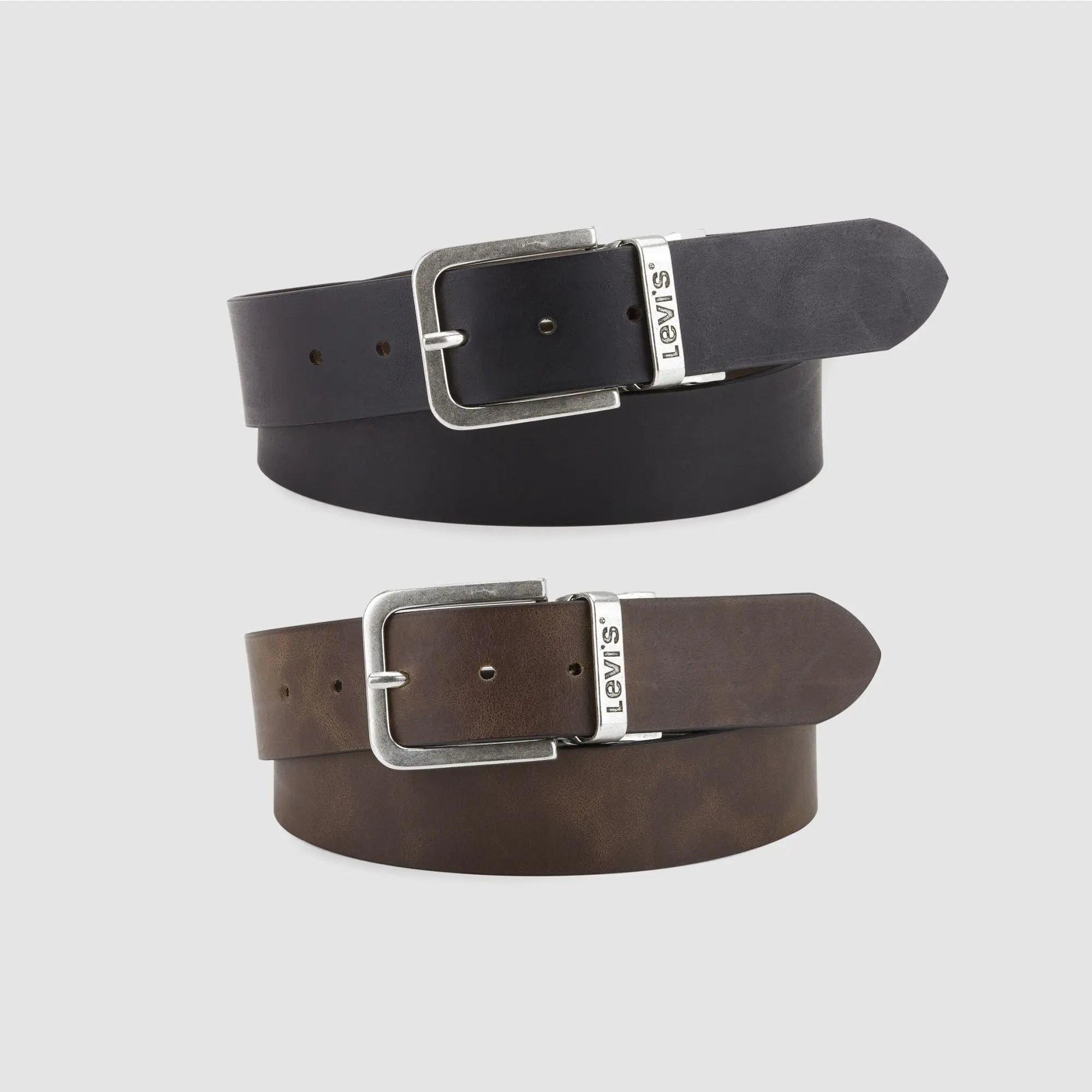 Ceinture Levi's Legacy réversible en cuir : face noire enroulée au-dessus de la face marron, boucle argent vieilli