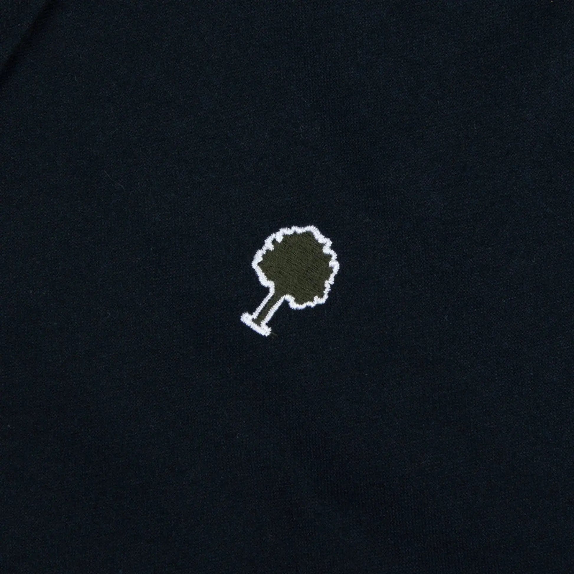 Détail du logo arbre Faguo en feutre kaki cerné de blanc sur l'oxford gratté bleu marine de la chemise Ivoy