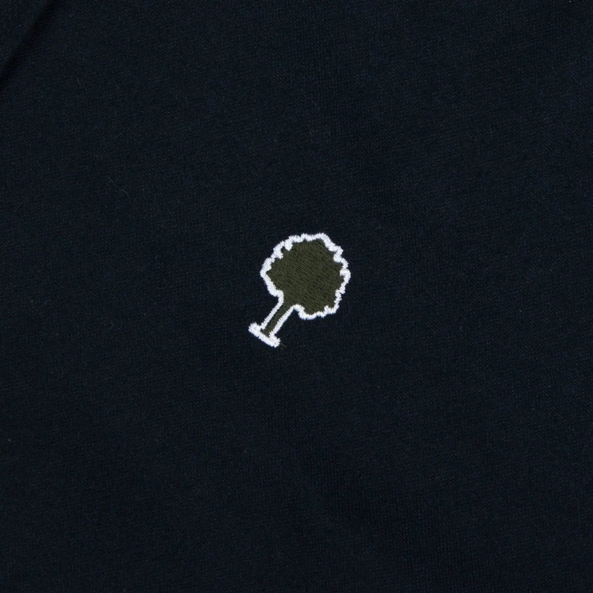 Détail du logo arbre Faguo en feutre kaki cerné de blanc sur l'oxford gratté bleu marine de la chemise Ivoy