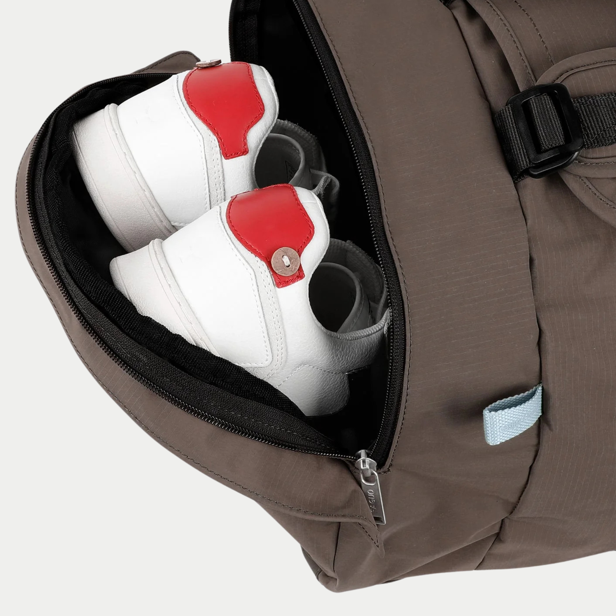 Compartiment chaussures zippé du Big Duffle chocolat, accessible de l’extérieur, avec une paire de baskets