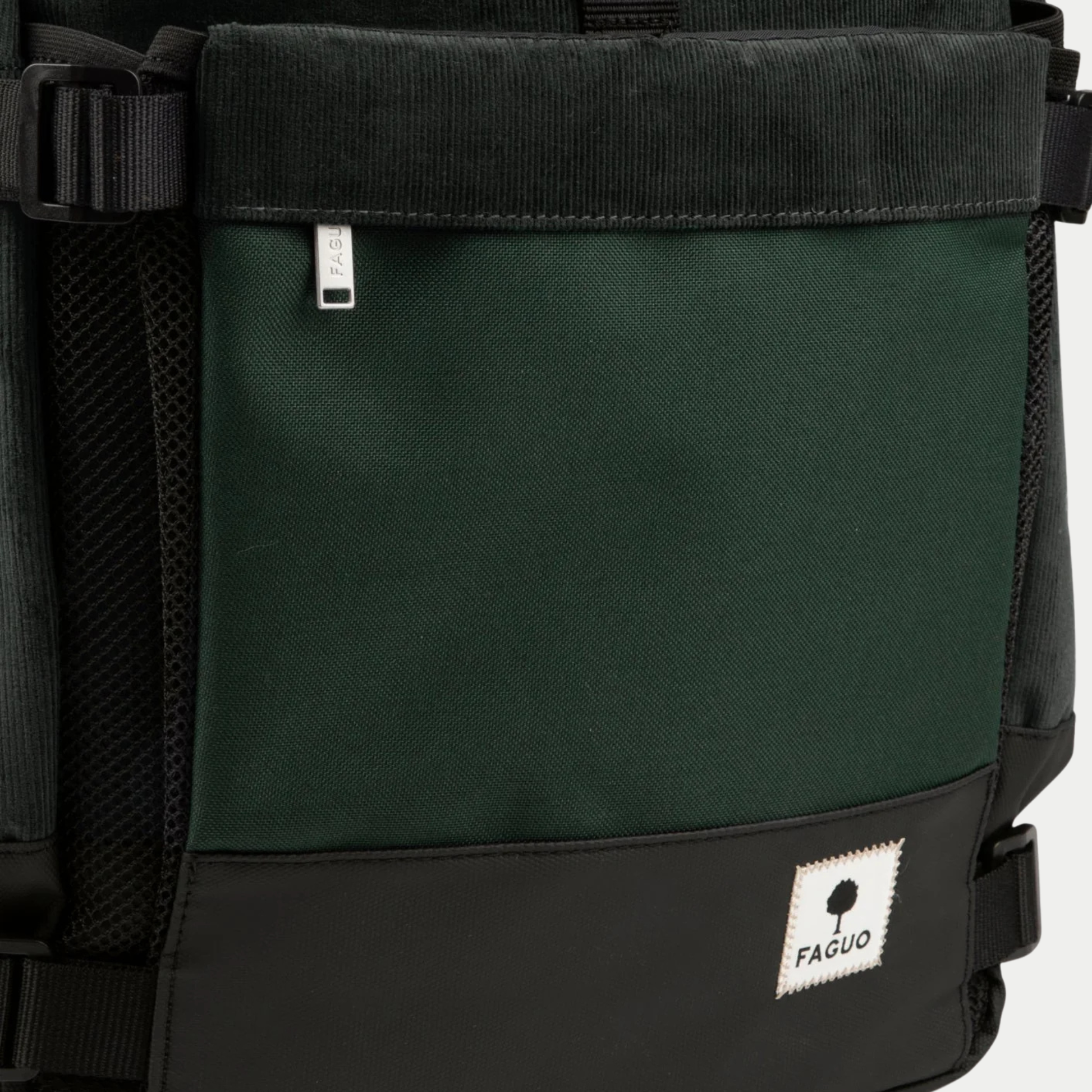 Détail du sac à dos Faguo Commuter 2.0 vert foncé : poche avant zippée, base noire enduite et étiquette tissée FAGUO