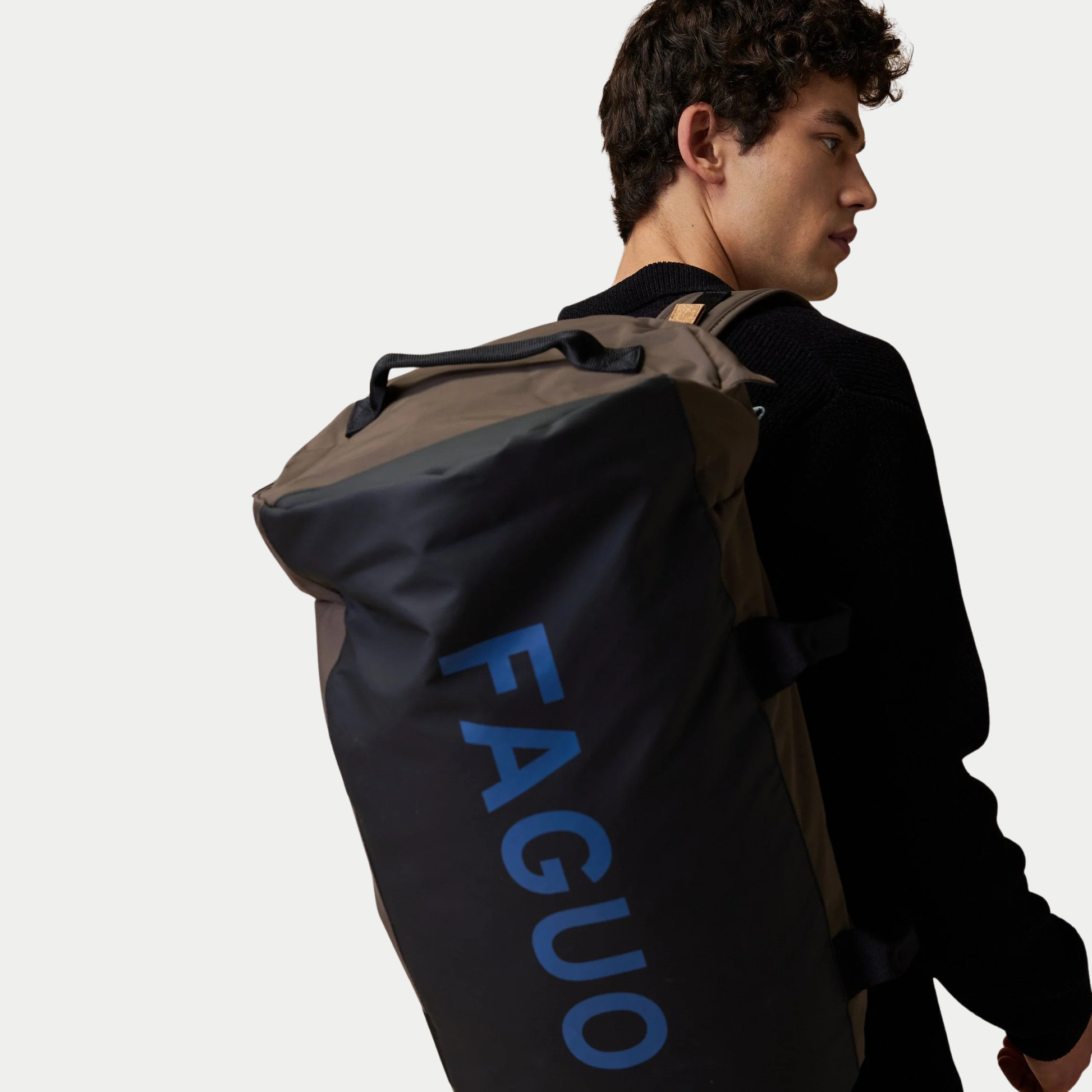 Big Duffle chocolat porté à l’épaule, face noire siglée FAGUO bleu