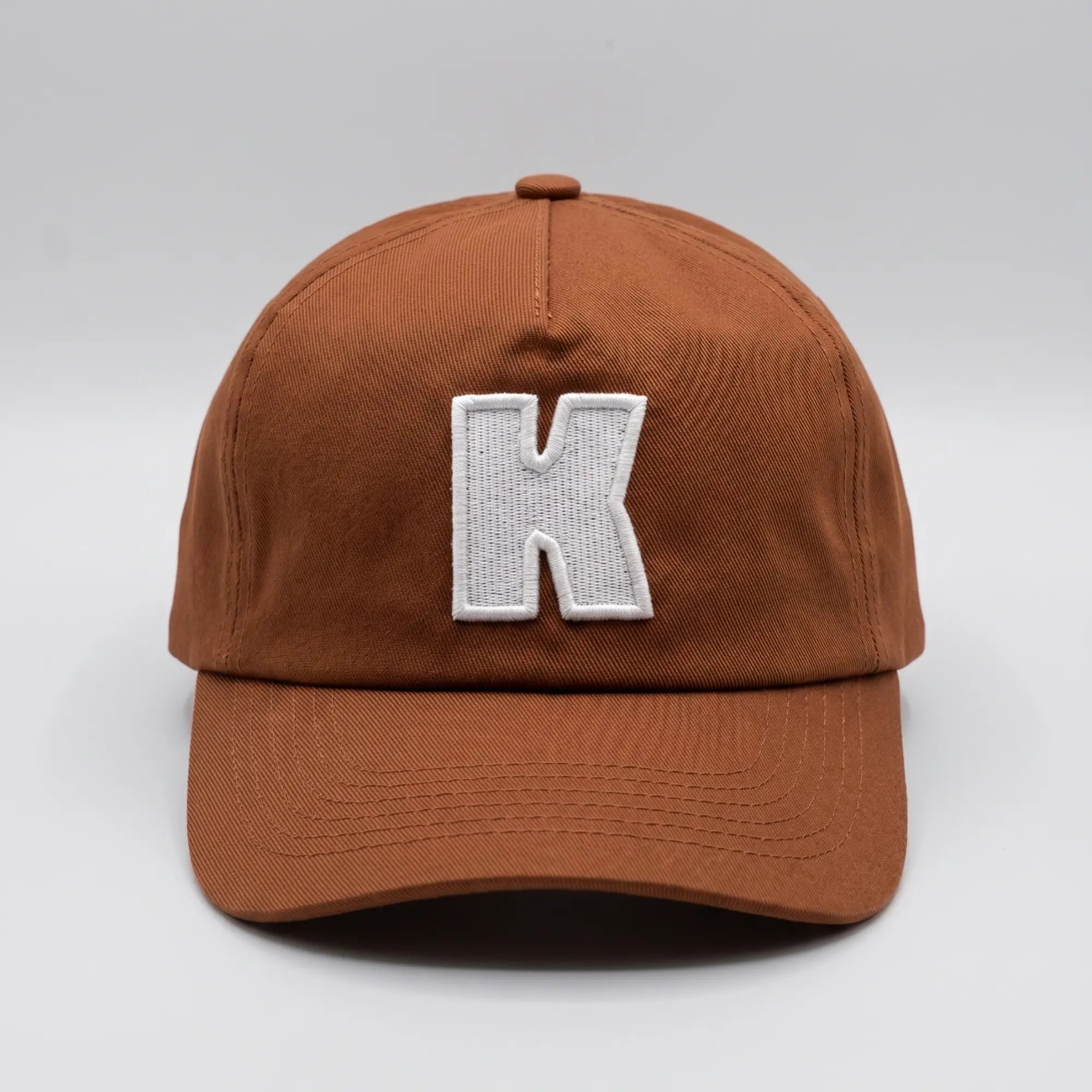 Casquette Klubb marron, vue de face avec le K blanc brodé en relief sur le panneau avant