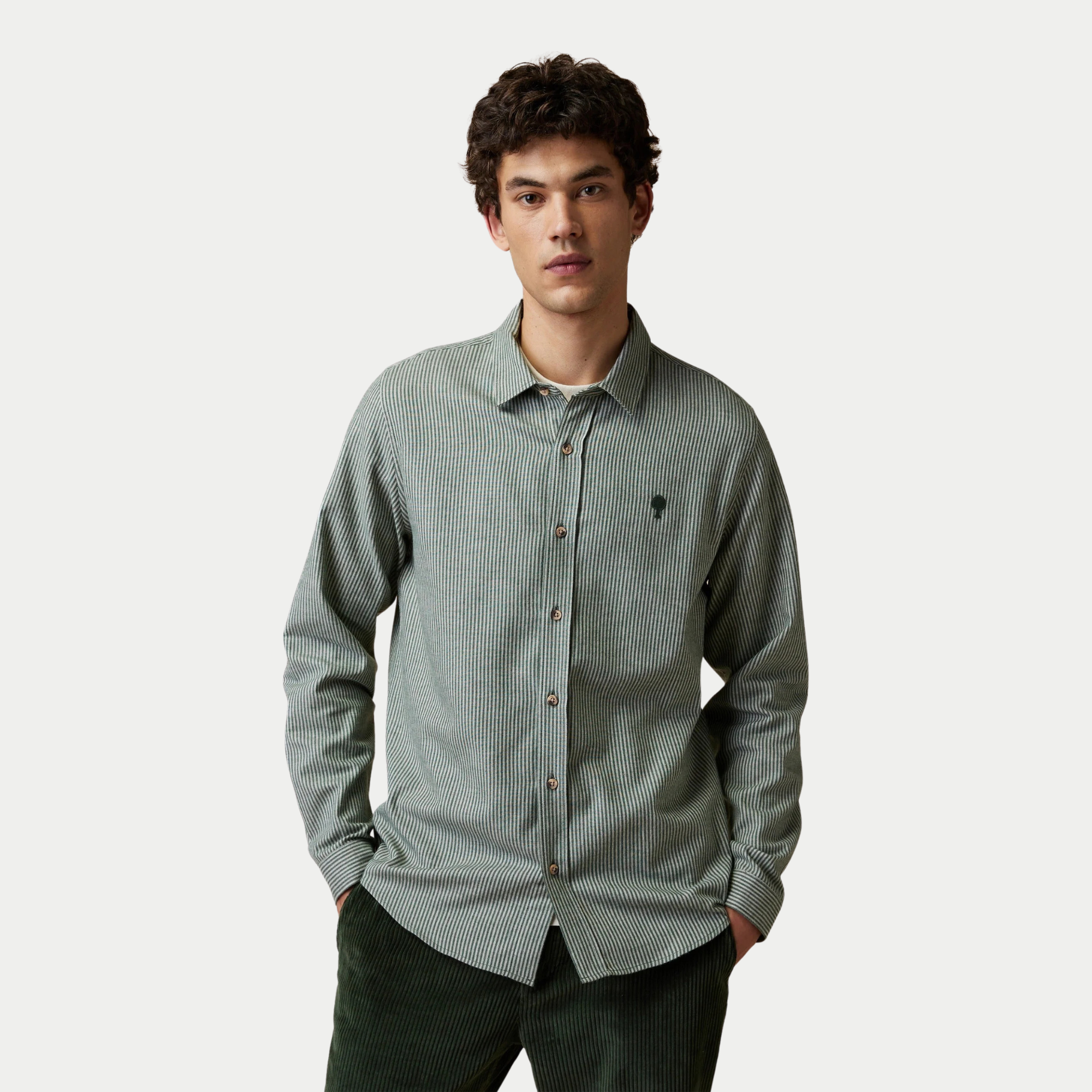 Chemise Iraty Faguo rayée vert foncé et écru portée boutonnée avec un pantalon en velours vert