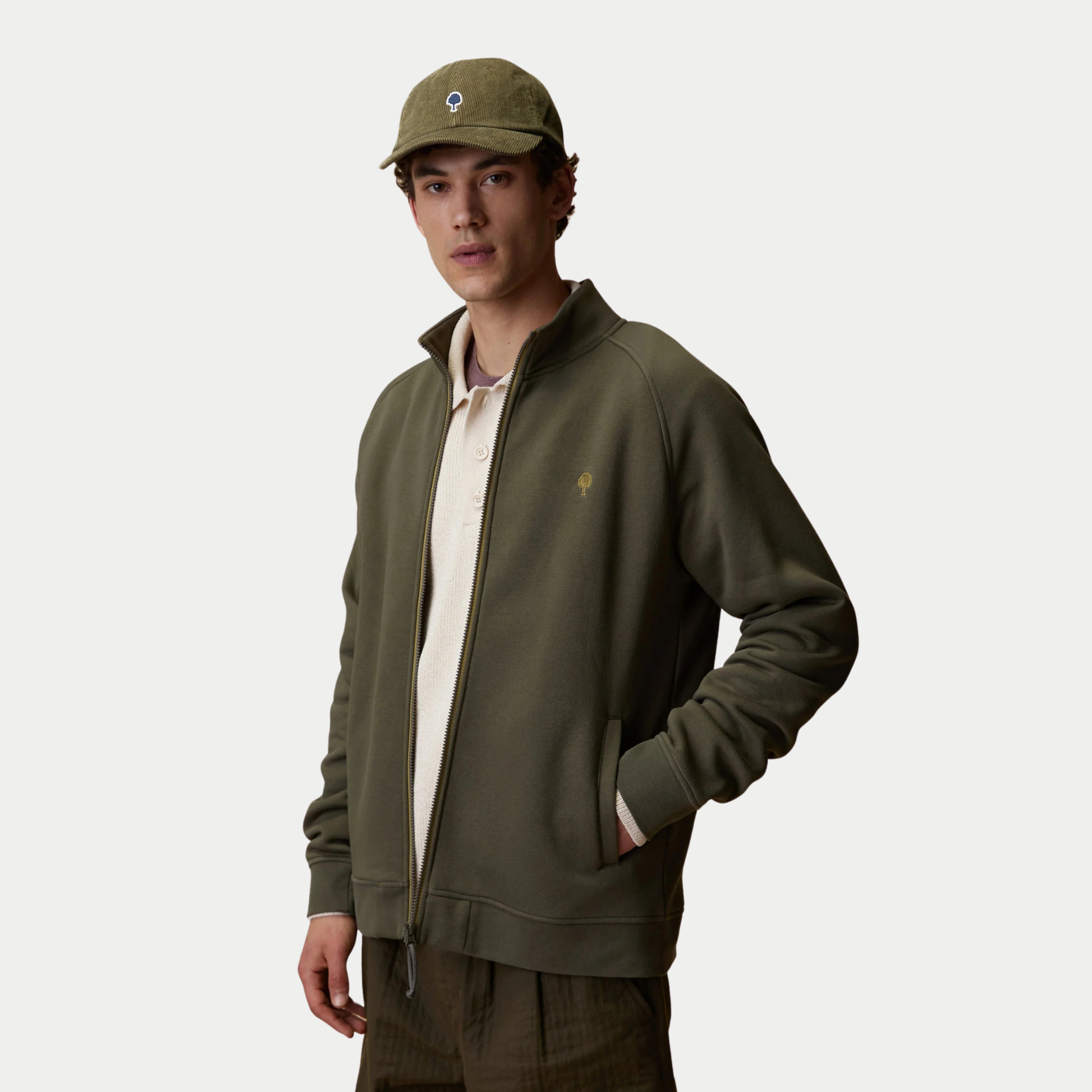 Sweat zippé Horte kaki Faguo porté ouvert sur un polo écru, vue trois quarts : manches raglan et poches côté