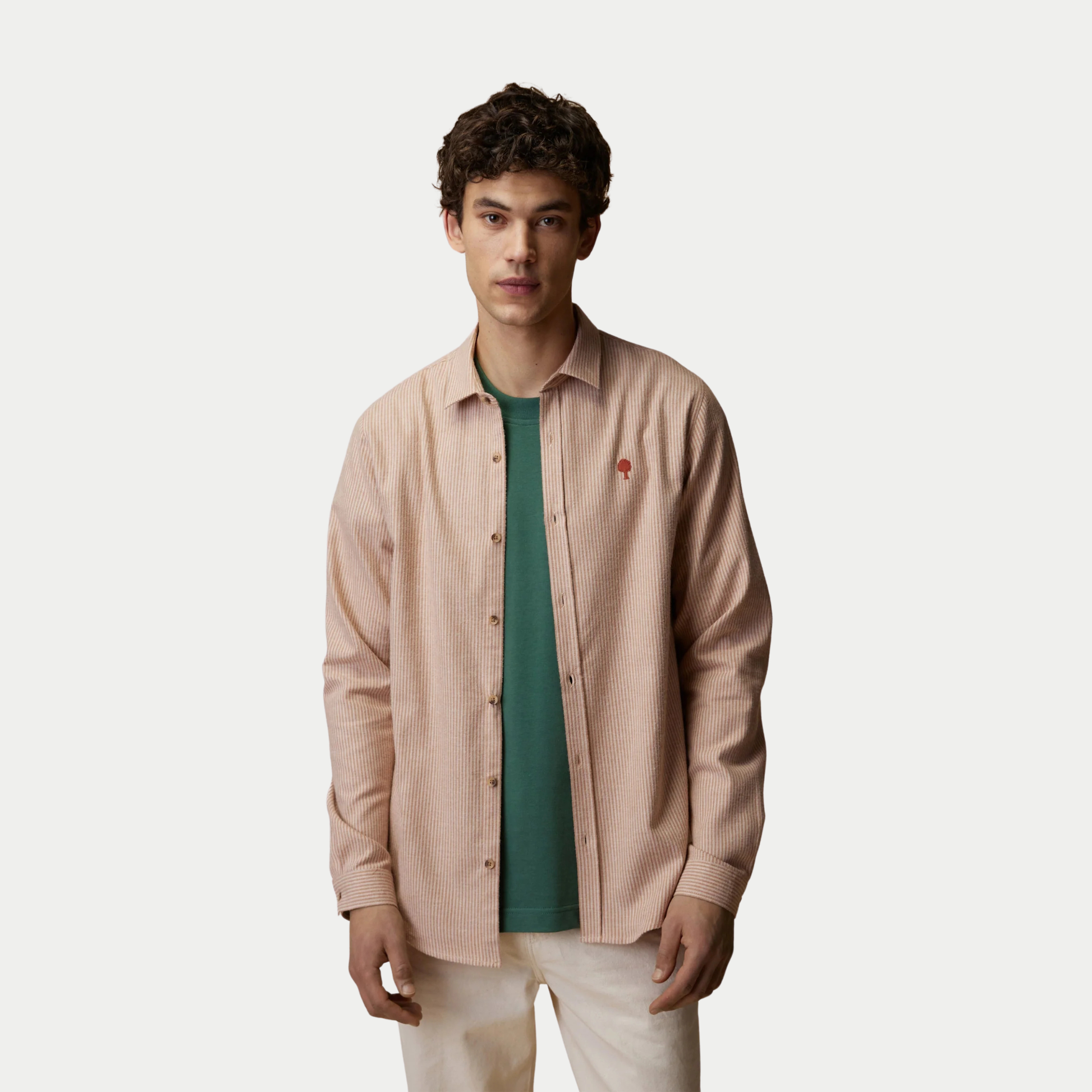 Chemise Iraty Faguo rayée crème et beige portée ouverte sur un t-shirt vert, vue de face