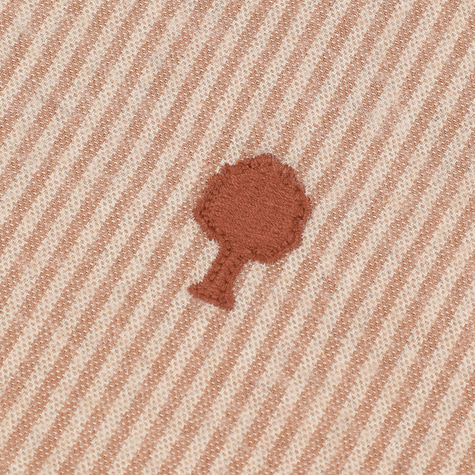 Gros plan sur la flanelle rayée crème et beige et l'arbre Faguo brodé terracotta de la chemise Iraty