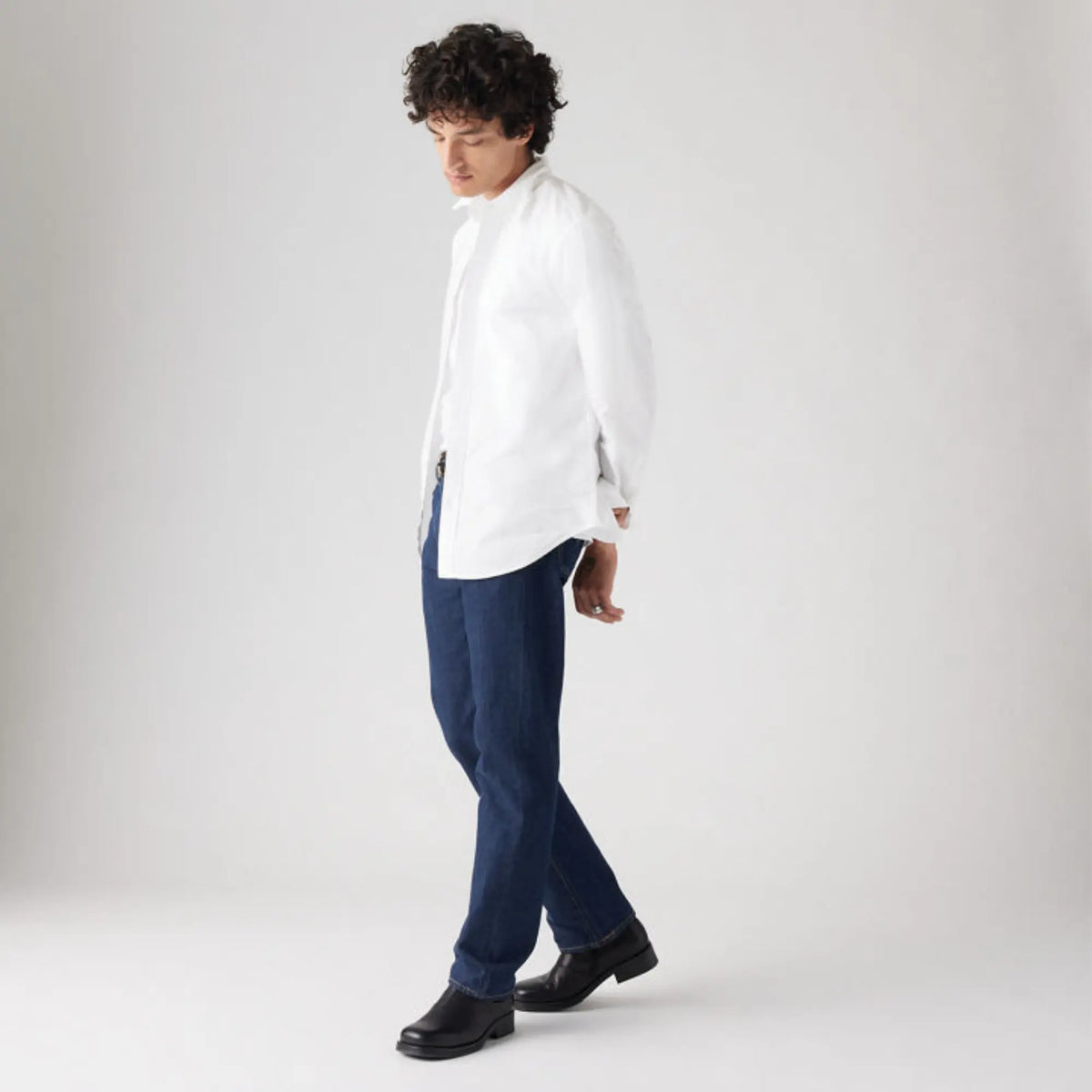 Homme en jean Levi's 501 Original One Wash porté avec une chemise blanche, vue de trois quarts en marche