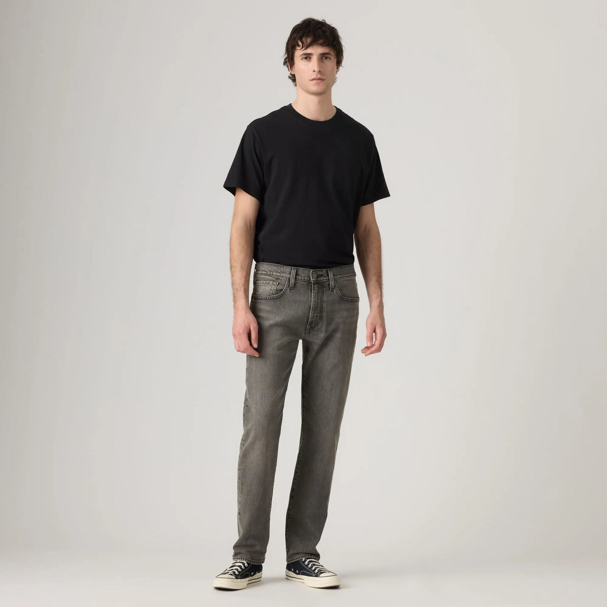 Jean Levi's 502 Taper Granite Shadow porté de face avec un t-shirt noir, silhouette plein pied