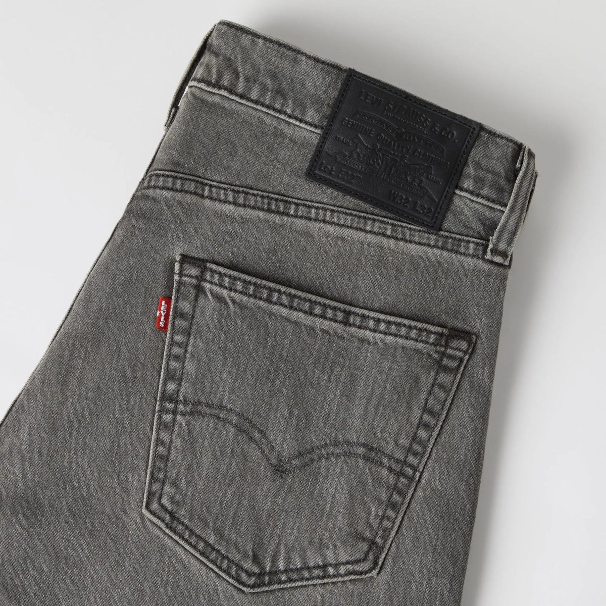 Détail du jean Levi's 502 Taper Granite Shadow : poche arrière arquée, tab rouge et patch cuir Lot 502