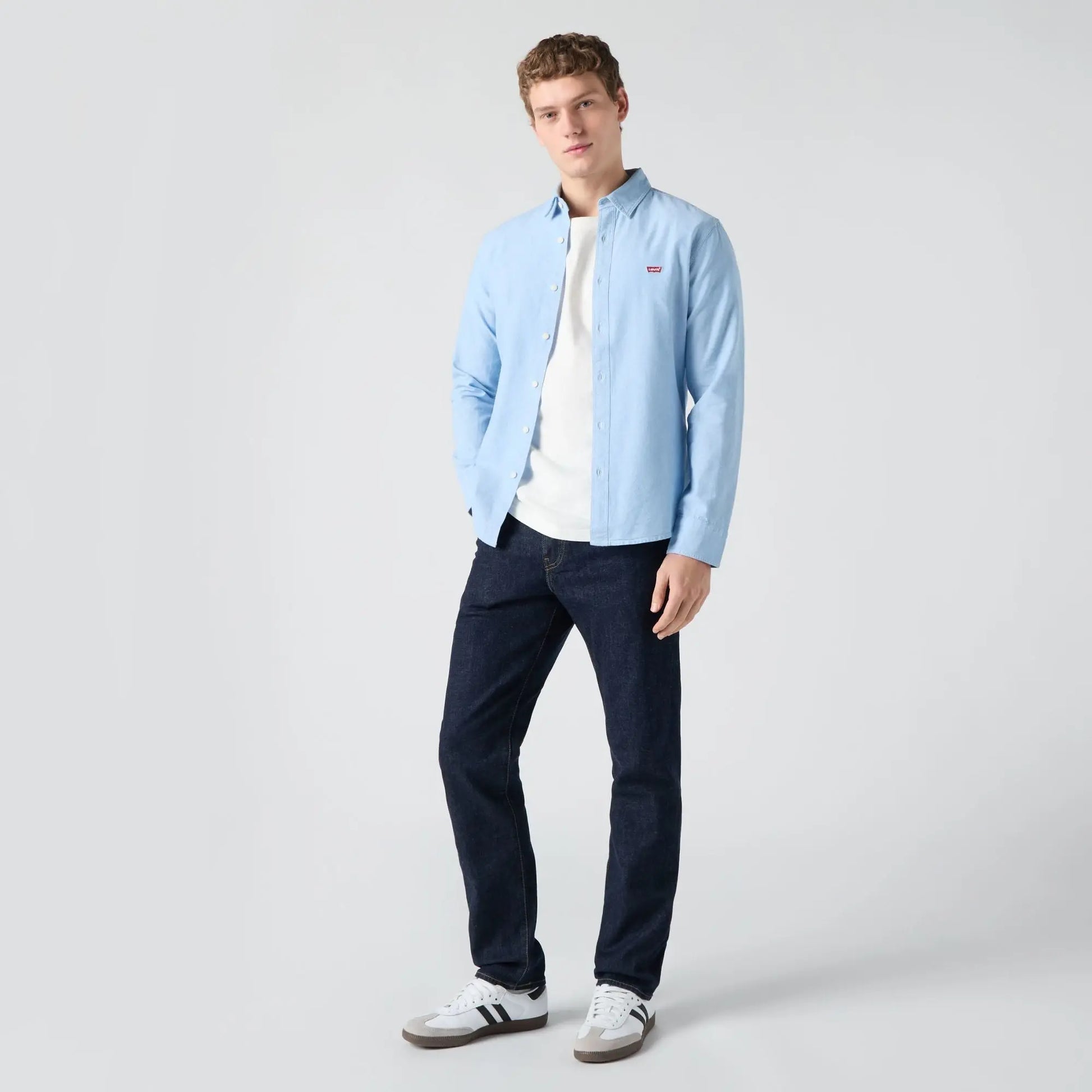 Jean Levi's 502 Taper Rock Cod porté de face avec chemise en jean bleu ciel et baskets blanches