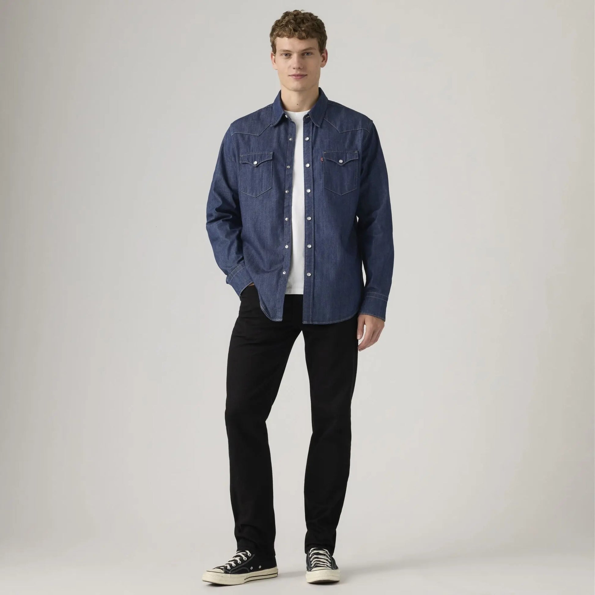 Jean Levi's 502 Taper Sta-Dark Black porté de face avec une chemise western en denim brut et des baskets noires