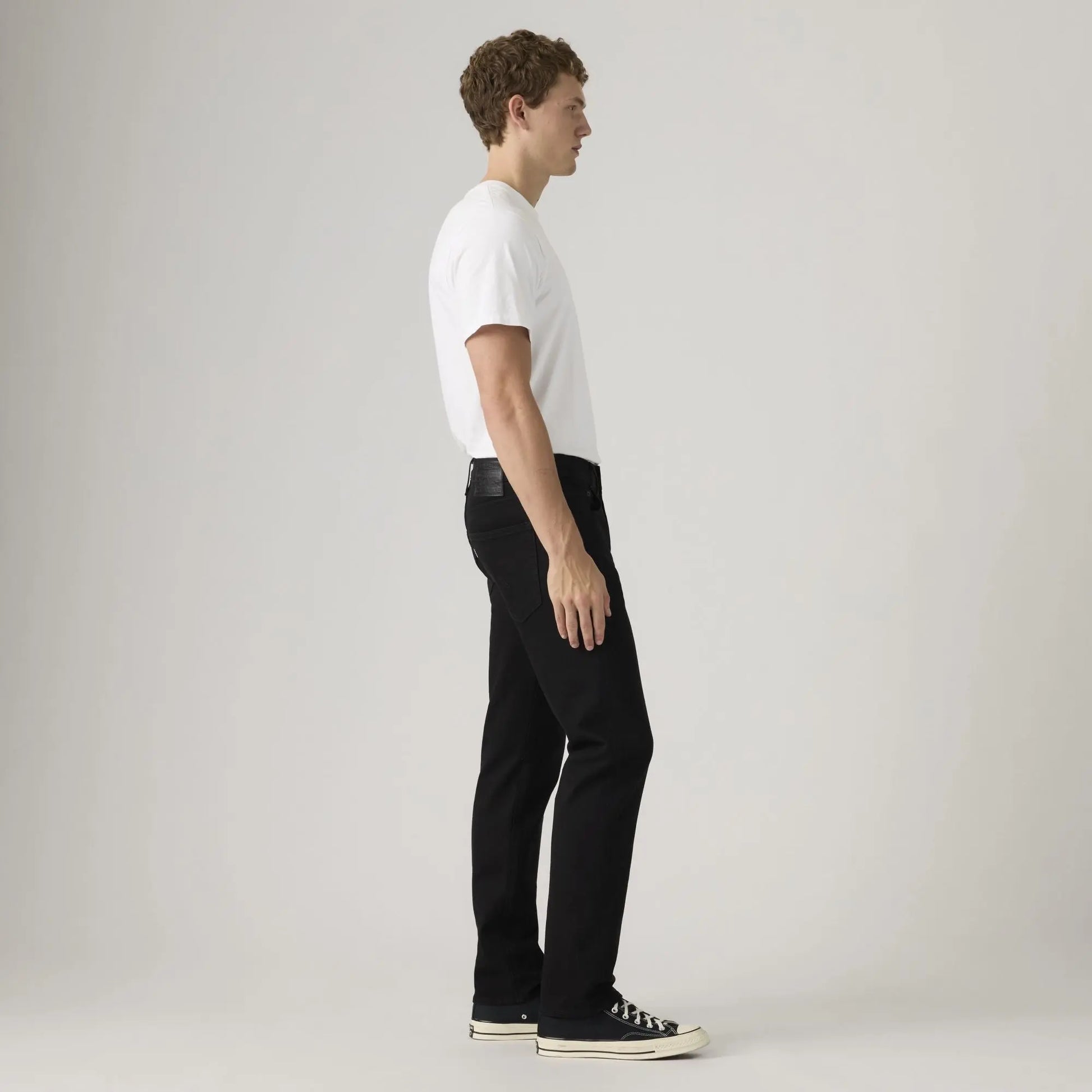 Jean Levi's 502 Taper Sta-Dark Black vu de profil, tombant fuselé jusqu'aux baskets basses