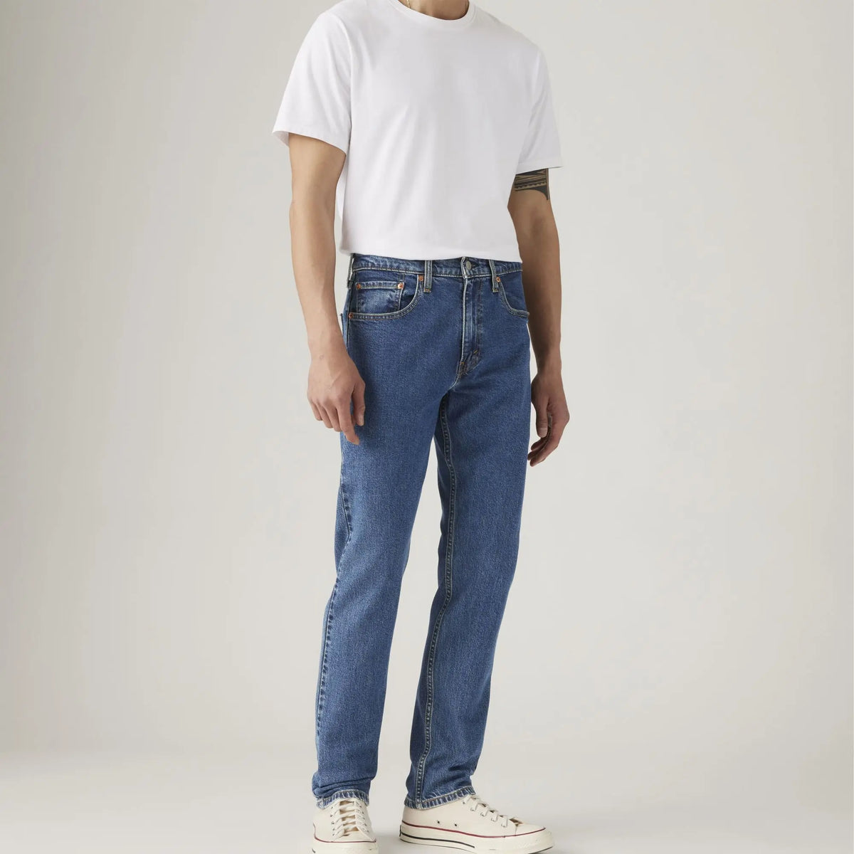 Jean Levi's 502 Taper Stonewash Stretch porté, cadrage buste-pieds avec T-shirt blanc : taille basse, jambe fuselée