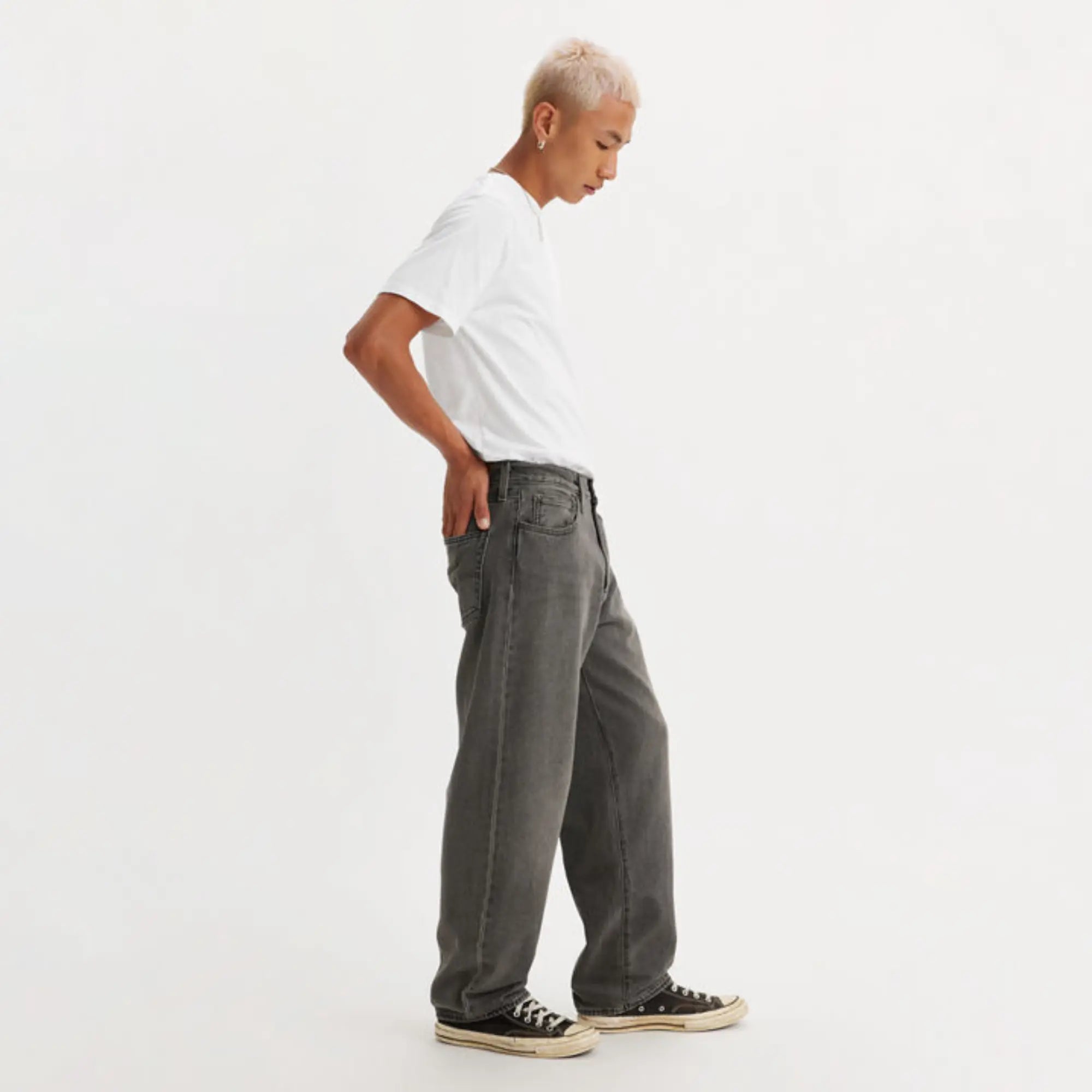 Jean 568 Loose Straight Dark Black Worn In porté de profil, silhouette loose et ourlet sur la cheville