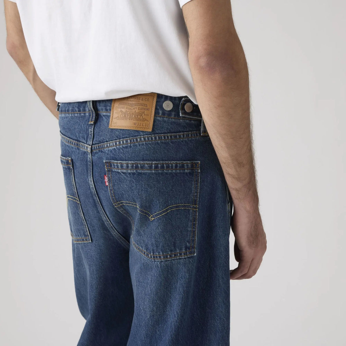 Détail de dos du jean Levi's Baggy Barrel Max Volume porté : patch cuir Levi Strauss, tab rouge et surpiqûres orangées