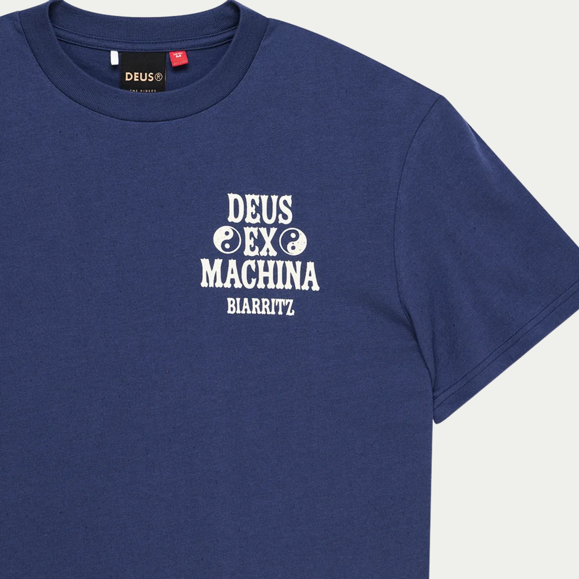 Buste du T-shirt Biarritz Ceramic bleu marine en gros plan : imprimé écru aux yin-yang et étiquette Deus sous l'encolure