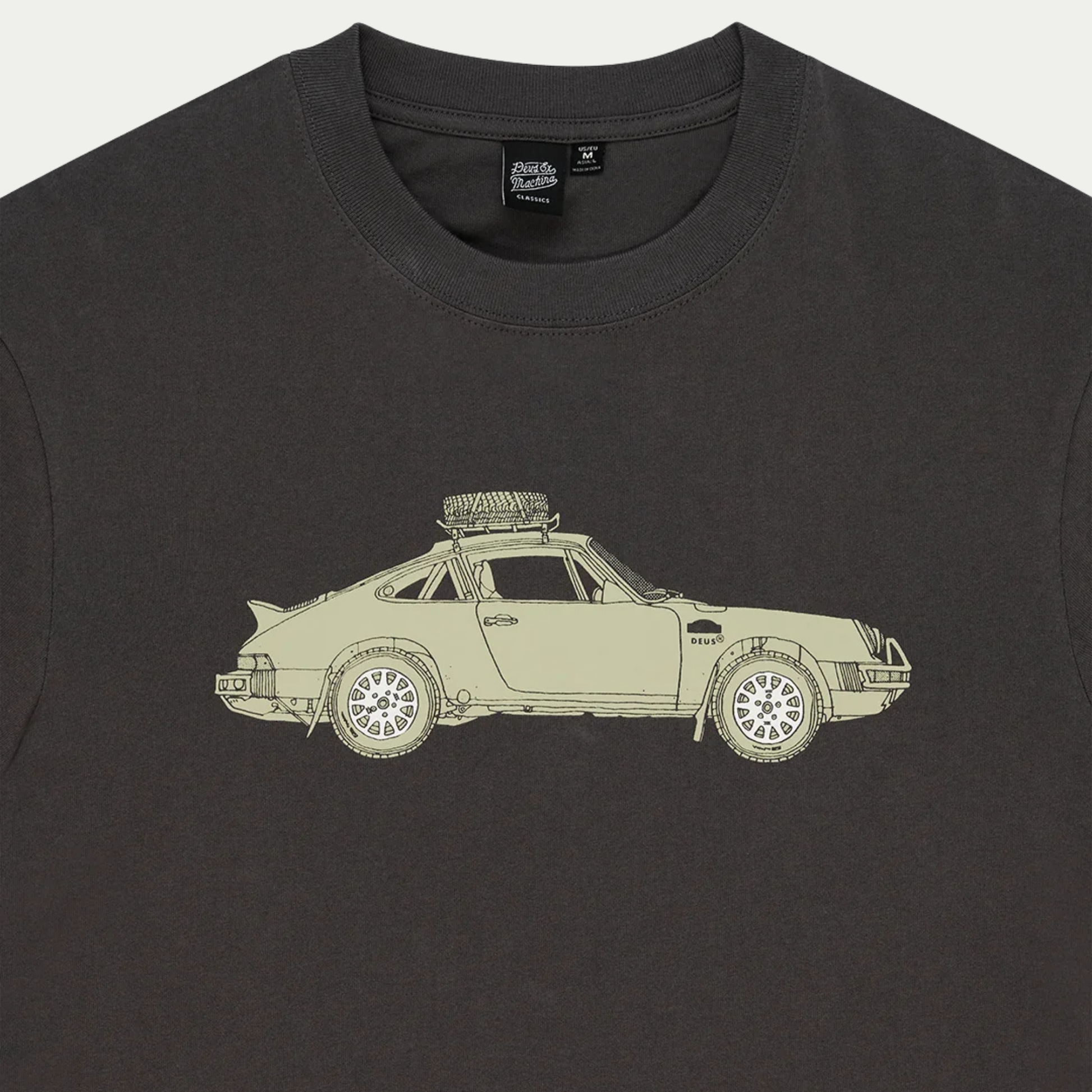 Détail de l’encolure du T-shirt Park anthracite : étiquette Deus Classics et haut de l’illustration Porsche 911 safari