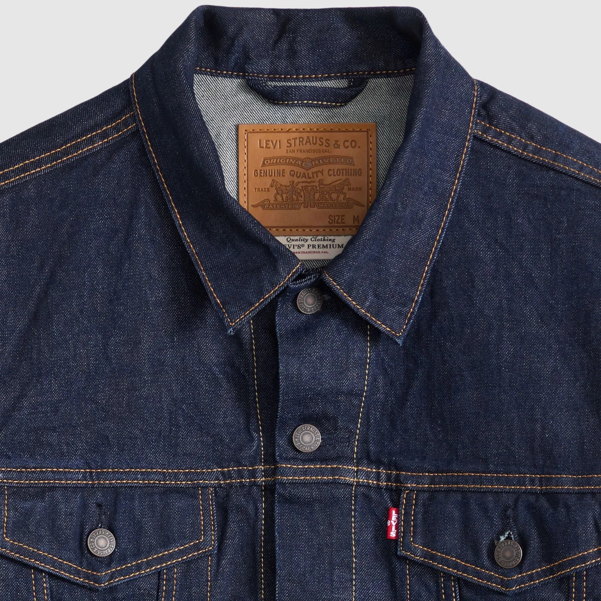 Détail du col de la veste Trucker Levi's Wash It Out Rinsed : patch cuir Levi Strauss, boutons métal, surpiqûres orange