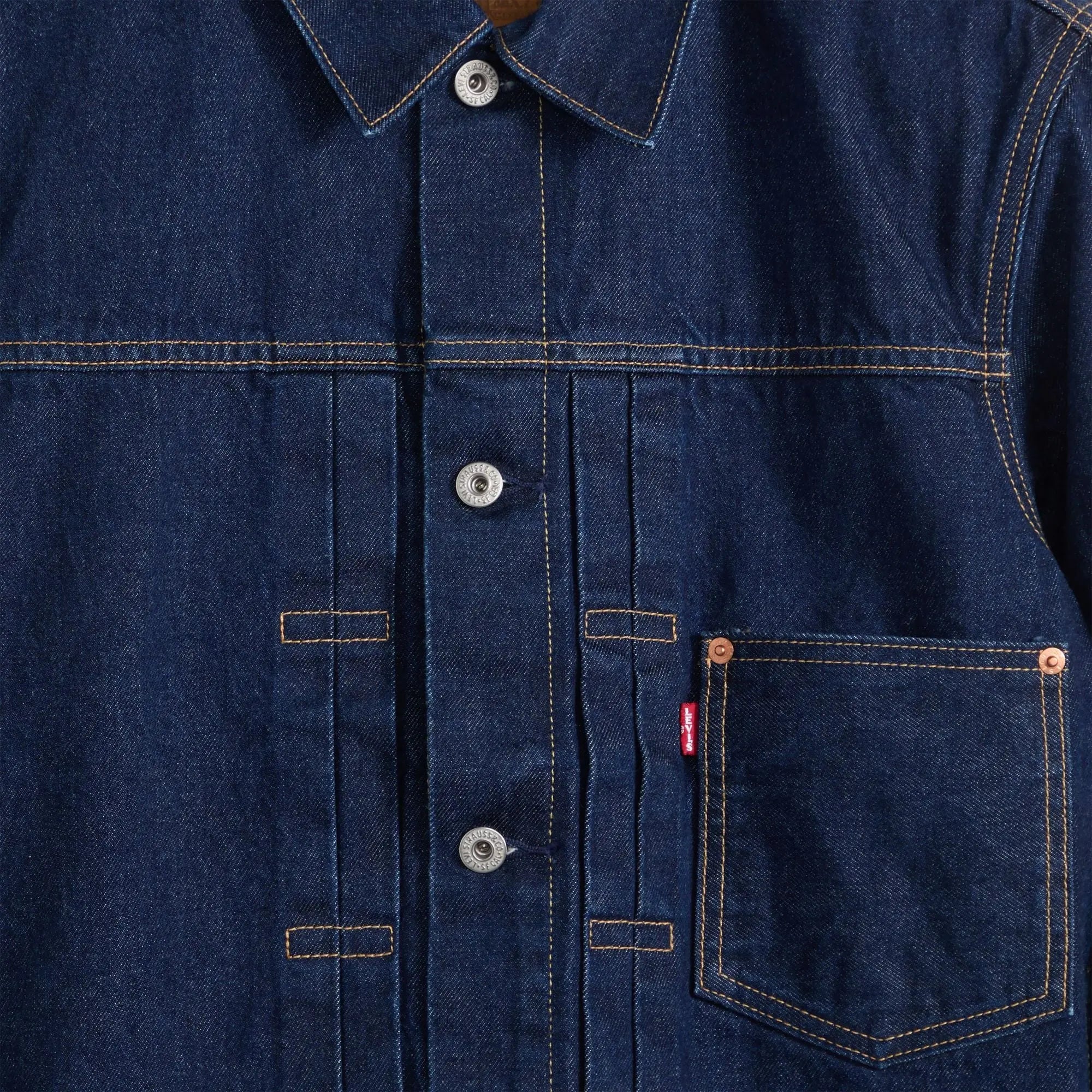Détail poitrine de la veste Levi's Type I Trucker : boutons gravés Levi Strauss & Co, plis et rivets cuivre