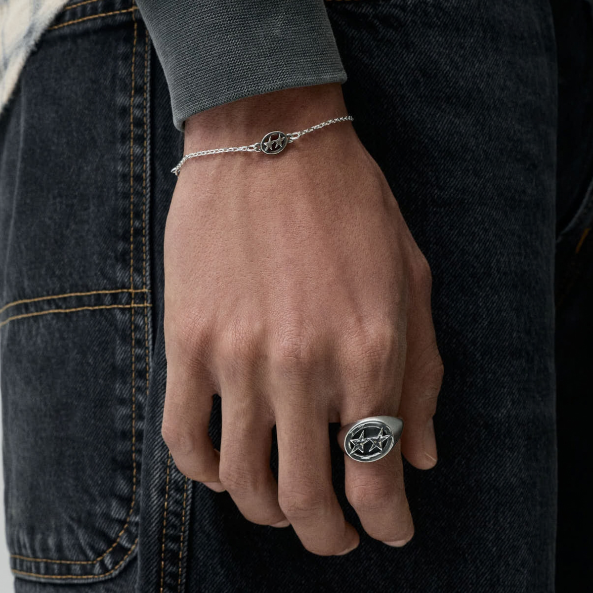 Bague Icon Signet argentée Twojeys portée à la main, avec un bracelet chaîne