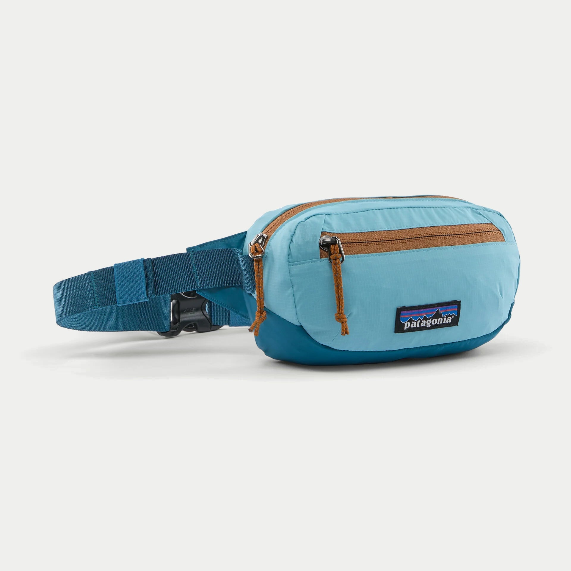 Banane Terravia Mini Hip Snowmelt Blue Patagonia - trois quarts face, poche zippée caramel et sangle déployée