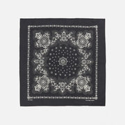 Bandana noir déplié à plat, motif paisley et médaillons imprimés en blanc cassé