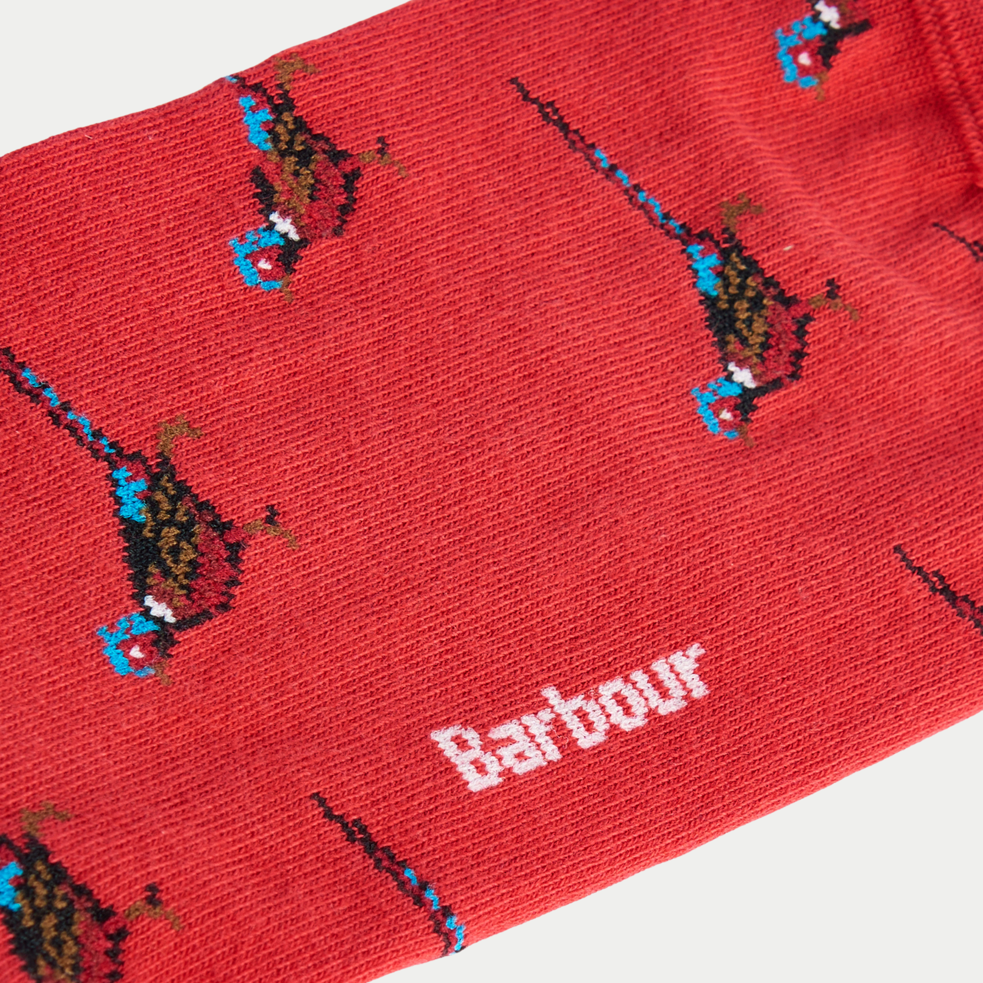 Détail de la maille rouge des chaussettes Mavin : faisan cuivré en intarsia, collerette blanche et logo Barbour