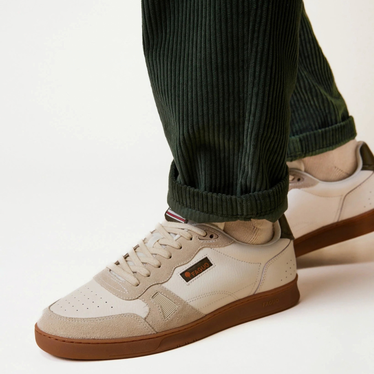 Baskets Commute 1 écru et kaki Faguo portées avec un pantalon en velours côtelé vert