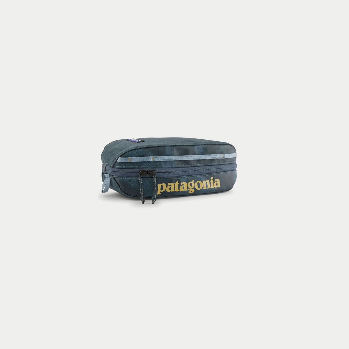 Cube Black Hole 3L Patagonia bleu ardoise, trois quarts : imprimé Sastrugi ton sur ton, zip double cordon, poignée claire.