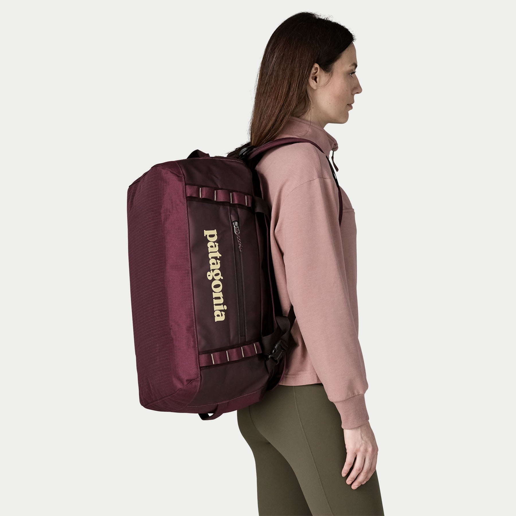 Duffel Black Hole 40L Berry Fig porté en sac à dos, bretelles rembourrées déployées, vue de profil