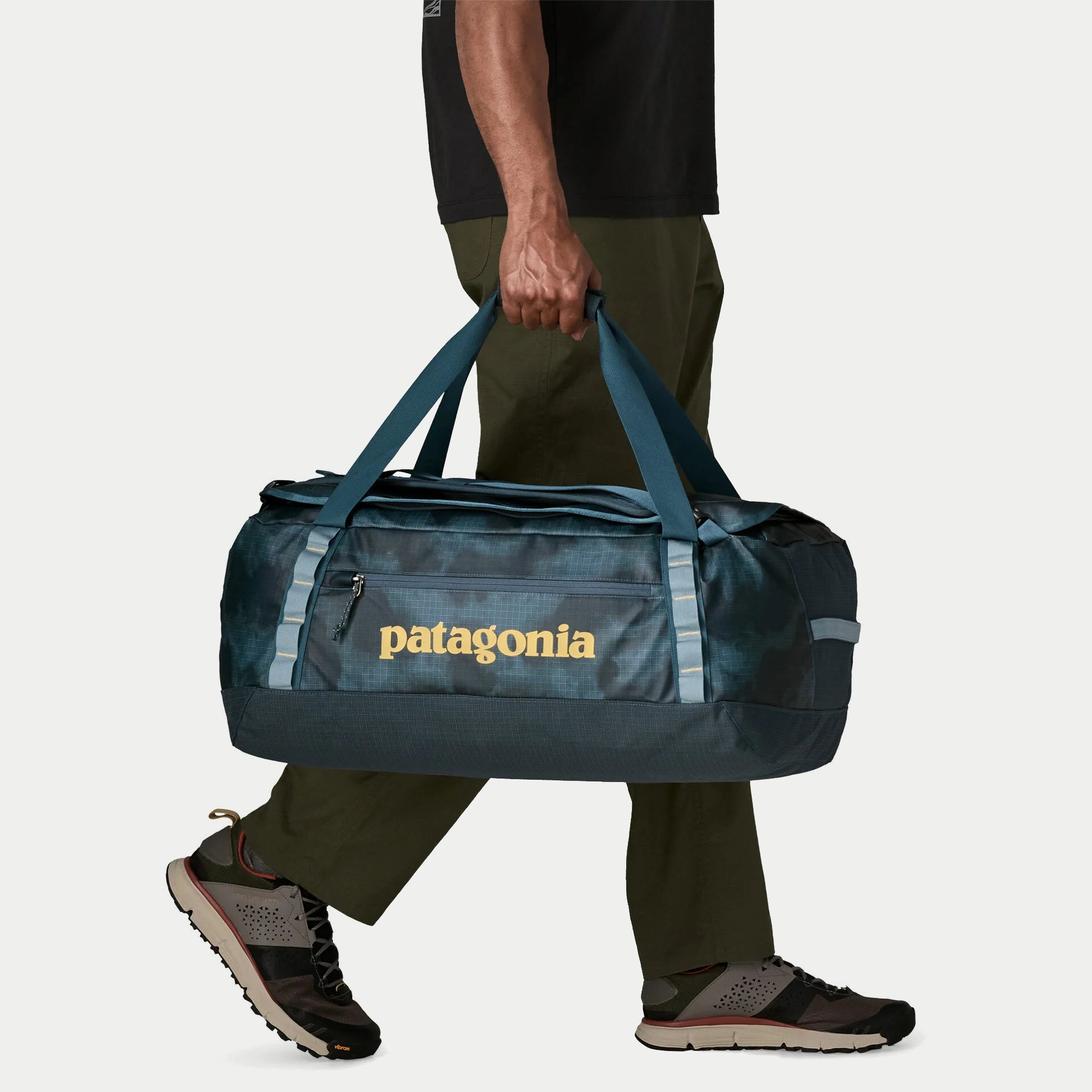 Black Hole Duffel 55L Summit Blue Patagonia porté à la main par ses deux poignées de portage renforcées