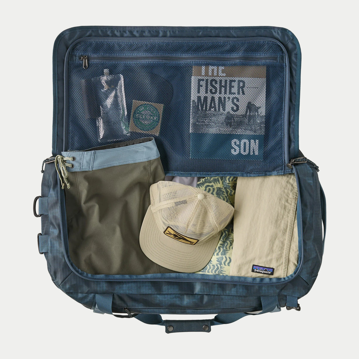 Black Hole Duffel 55L Summit Blue Patagonia ouvert à plat, intérieur bleu et poche filet zippée dans le couvercle