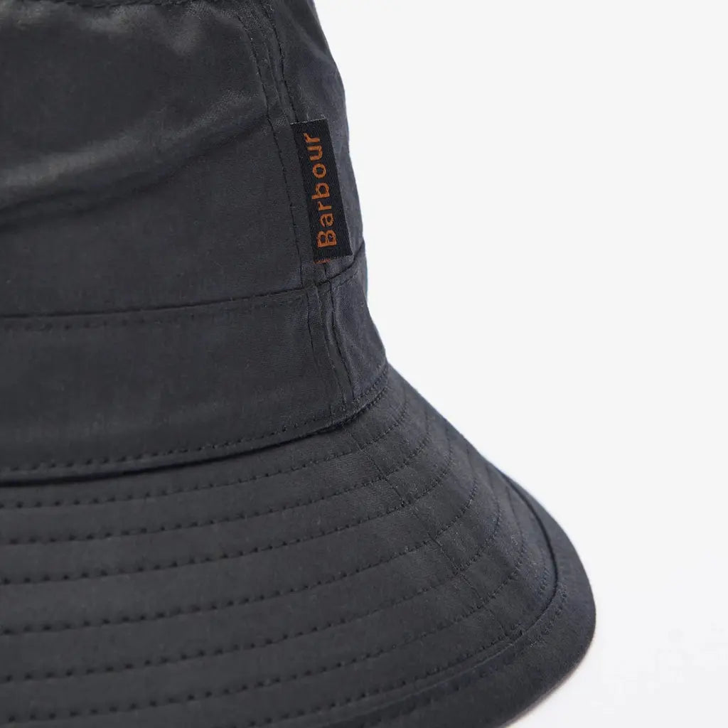 Macro de l'étiquette tissée noire à lettres orange sur le coton ciré du bob