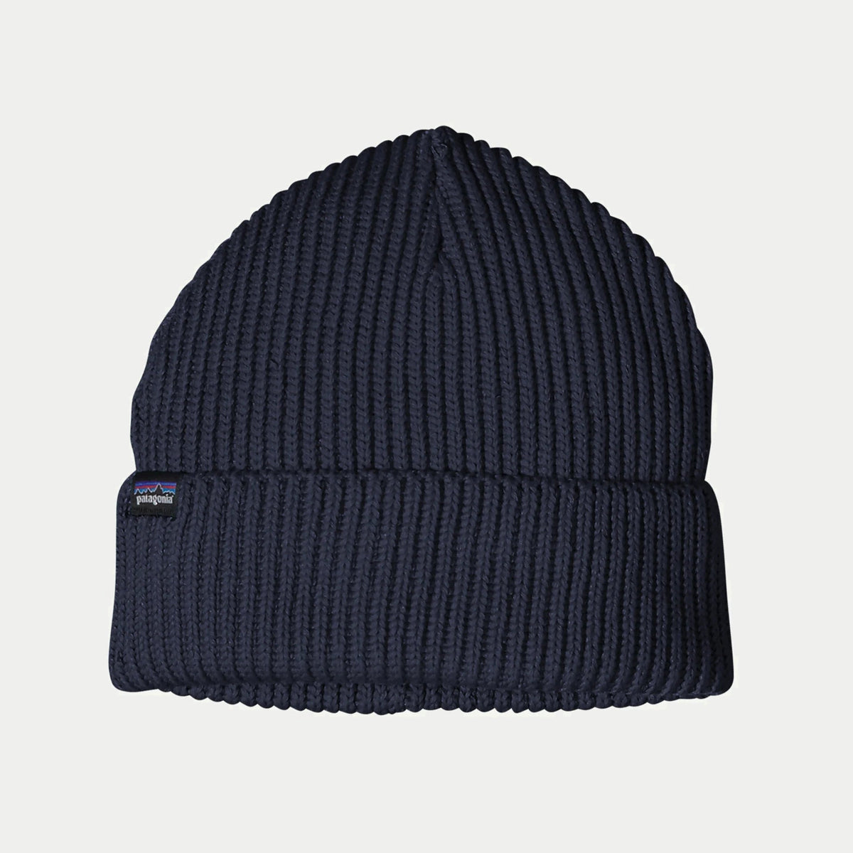 Bonnet Patagonia Fisherman's Rolled Navy Blue à plat, revers roulé côtelé et étiquette tissée sur le revers