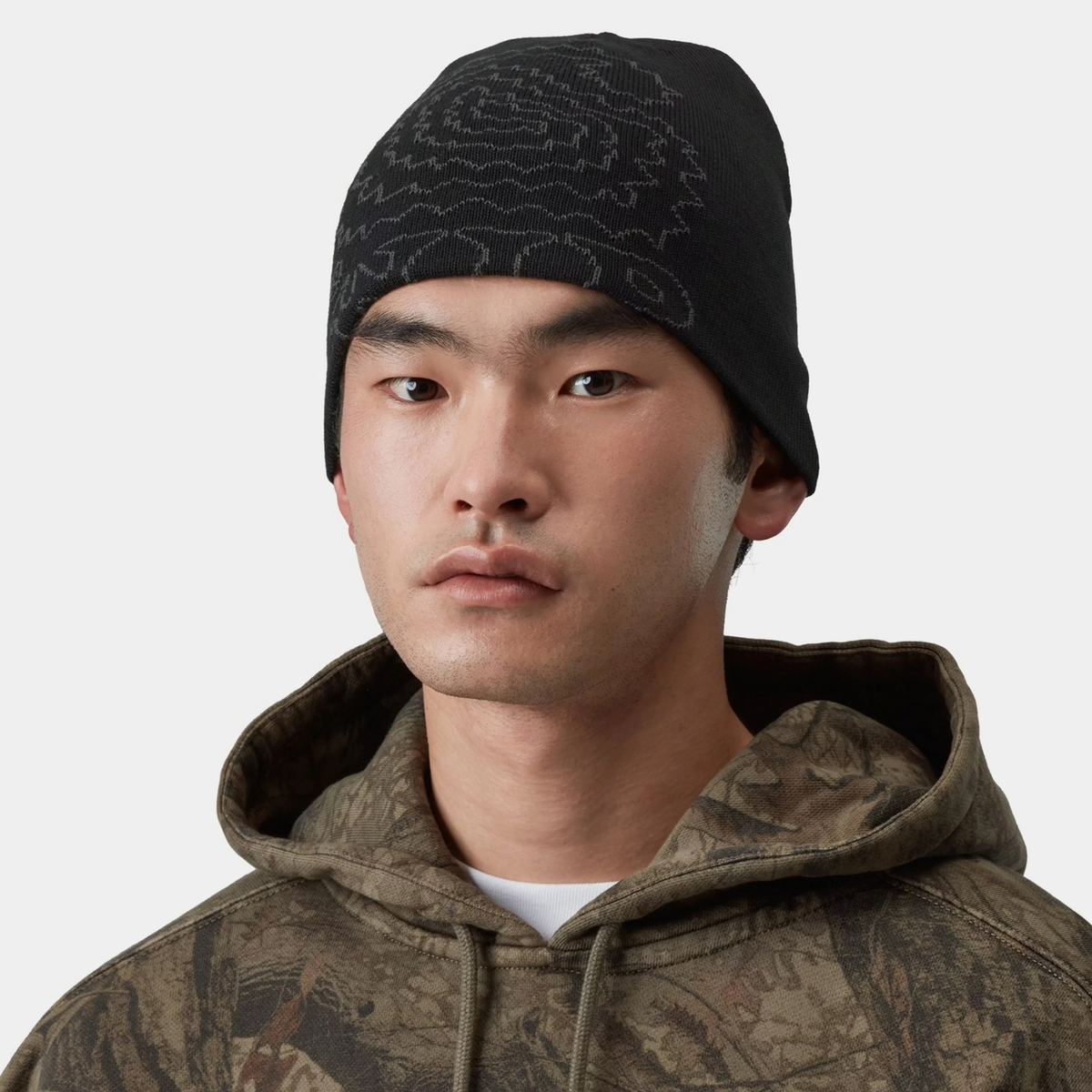 Bonnet Limn C noir Carhartt WIP porté, calotte courte sans revers, motif jacquard gris visible sur le devant