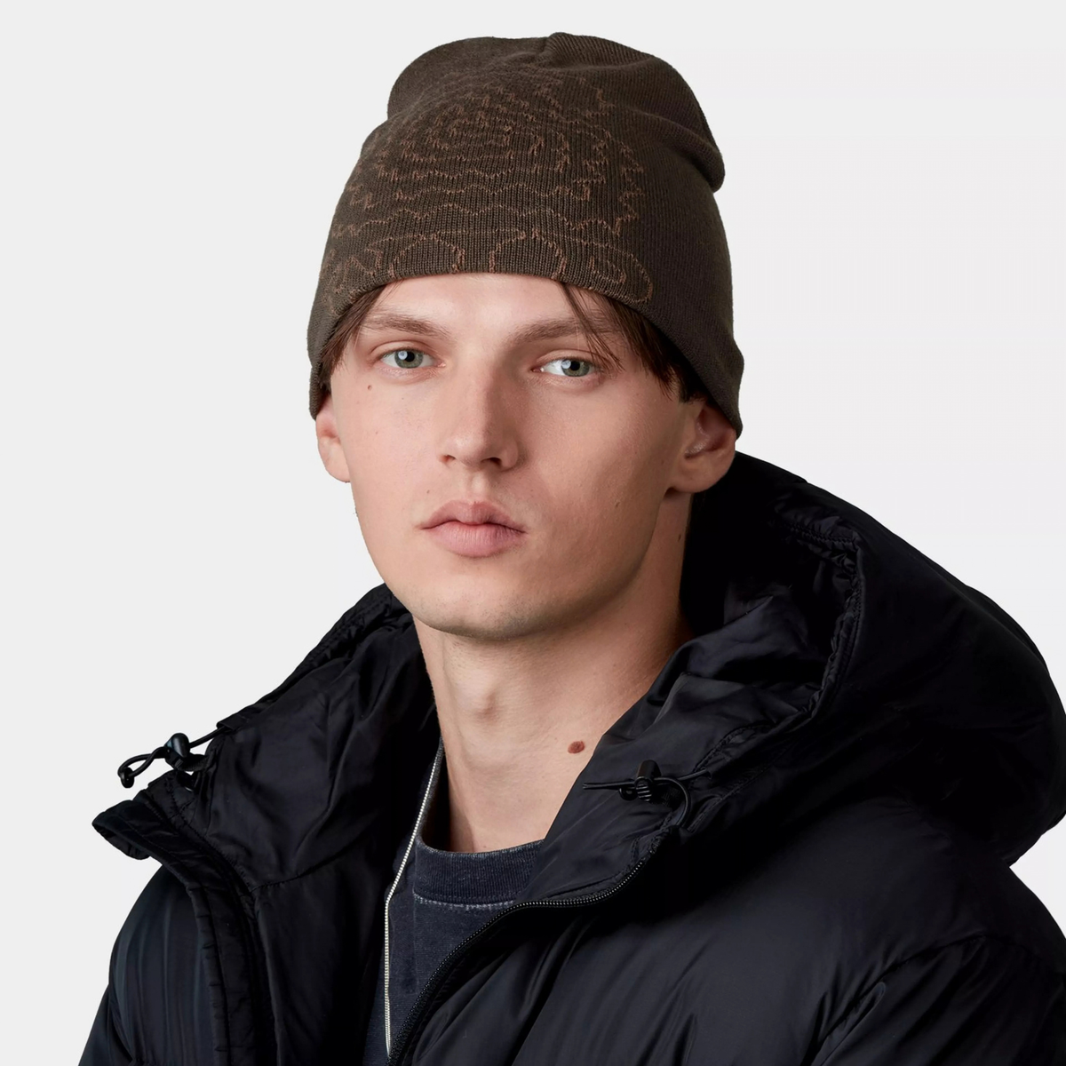 Bonnet Limn C Tobacco Carhartt WIP porté, bord replié sur le front, motif jacquard brun clair visible sur le devant