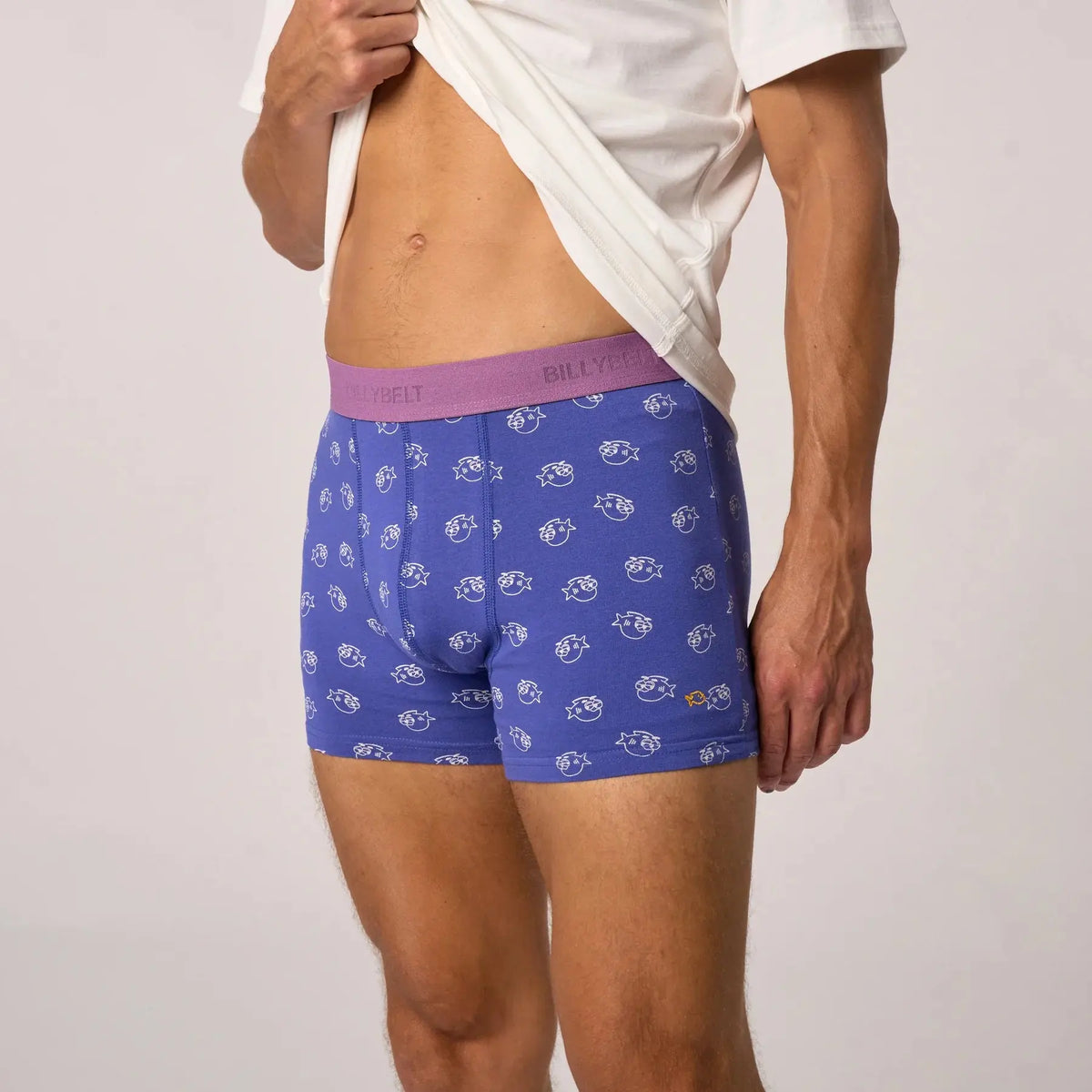 Boxer Billycool vu de profil, fond bleu roi couvert de poissons à lunettes de soleil dessinés en blanc