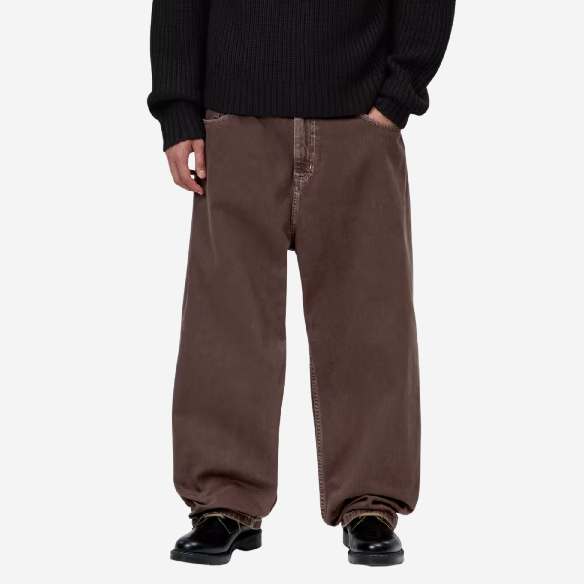 Pantalon Brandon Palisander Carhartt WIP porté de face avec un pull côtelé noir et des chaussures noires