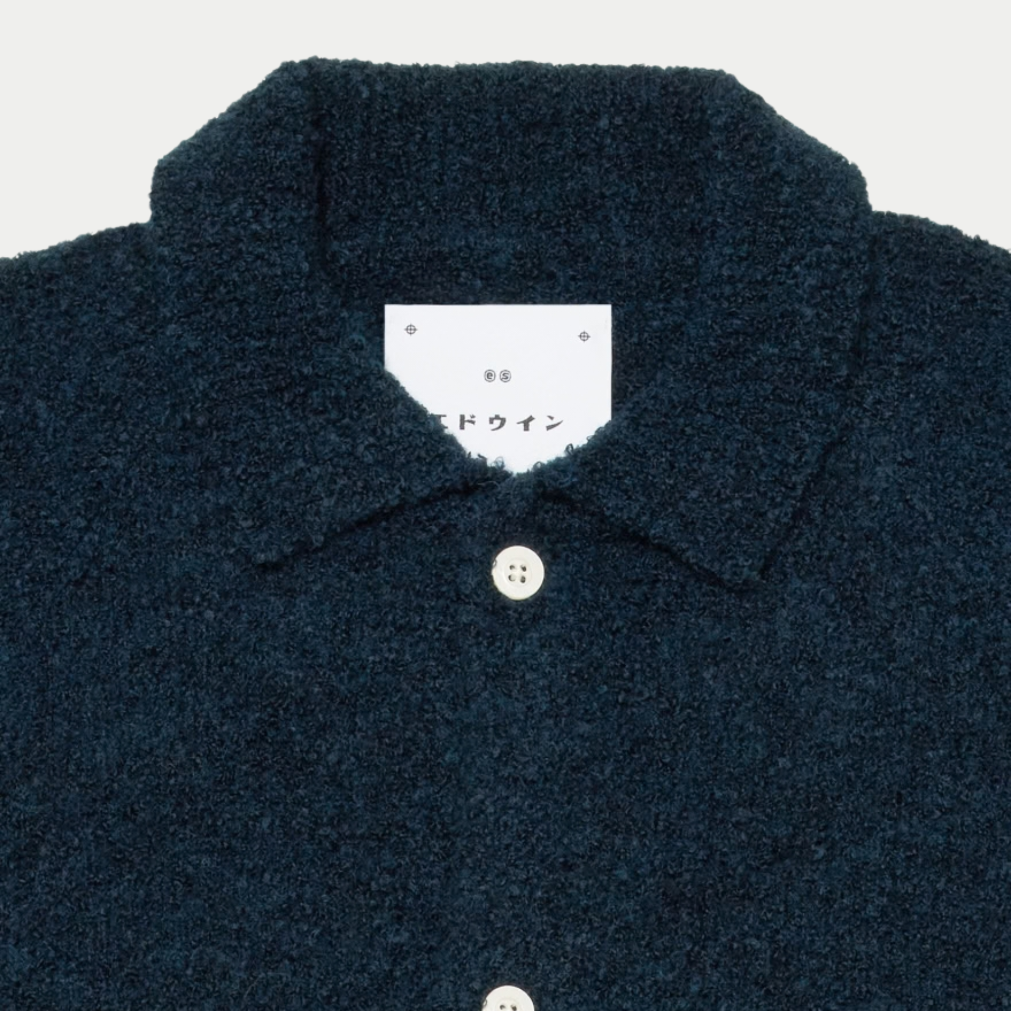 Détail du col chemise et de l’étiquette Edwin en katakana sur le cardigan Gemini bleu marine