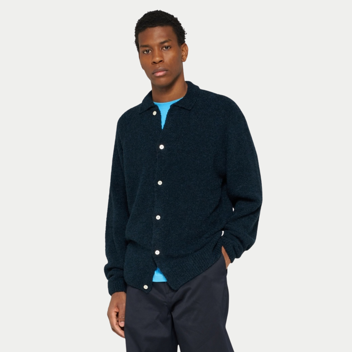 Cardigan Gemini bleu marine Edwin porté boutonné de face sur un t-shirt bleu vif
