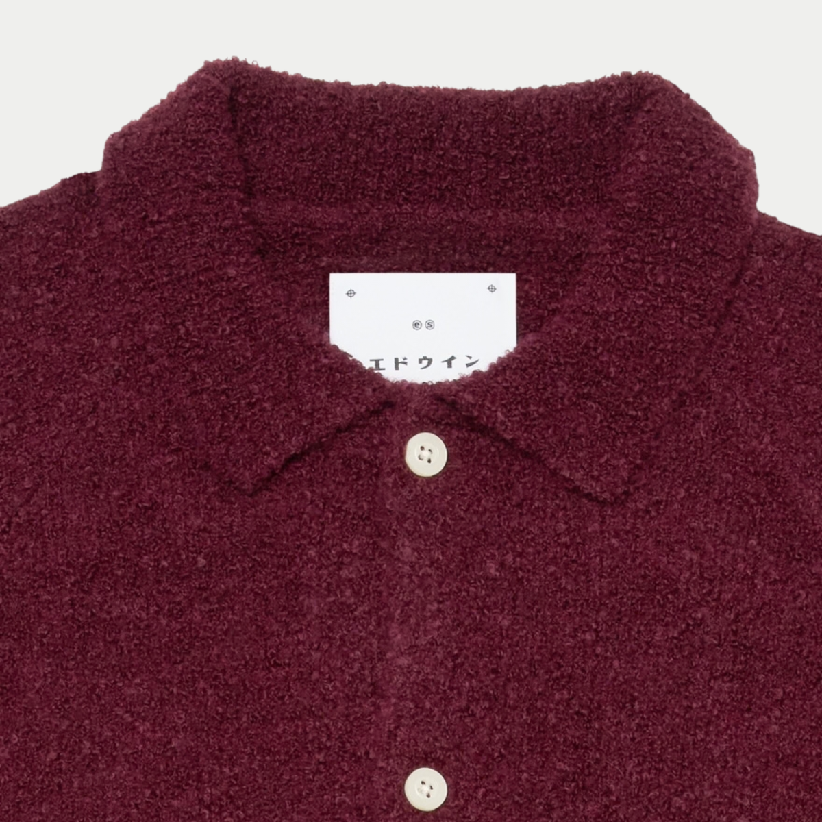 Macro du col chemise du cardigan Gemini Edwin bordeaux, étiquette Edwin en katakana et bouton ivoire