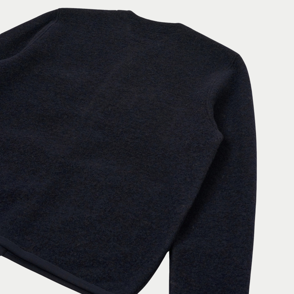 Dos à plat du cardigan en Wool Fleece bleu marine, emmanchure surpiquée et bas bordé d'un biais