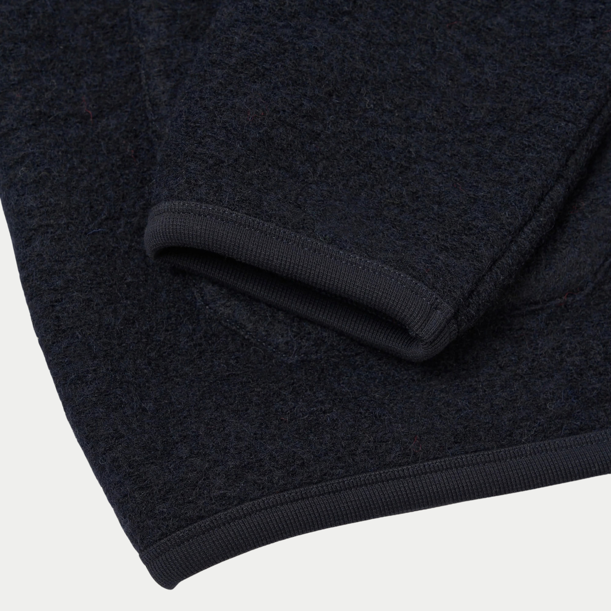 Poignet et ourlet du cardigan en Wool Fleece bleu marine bordés de côtes fines en coton