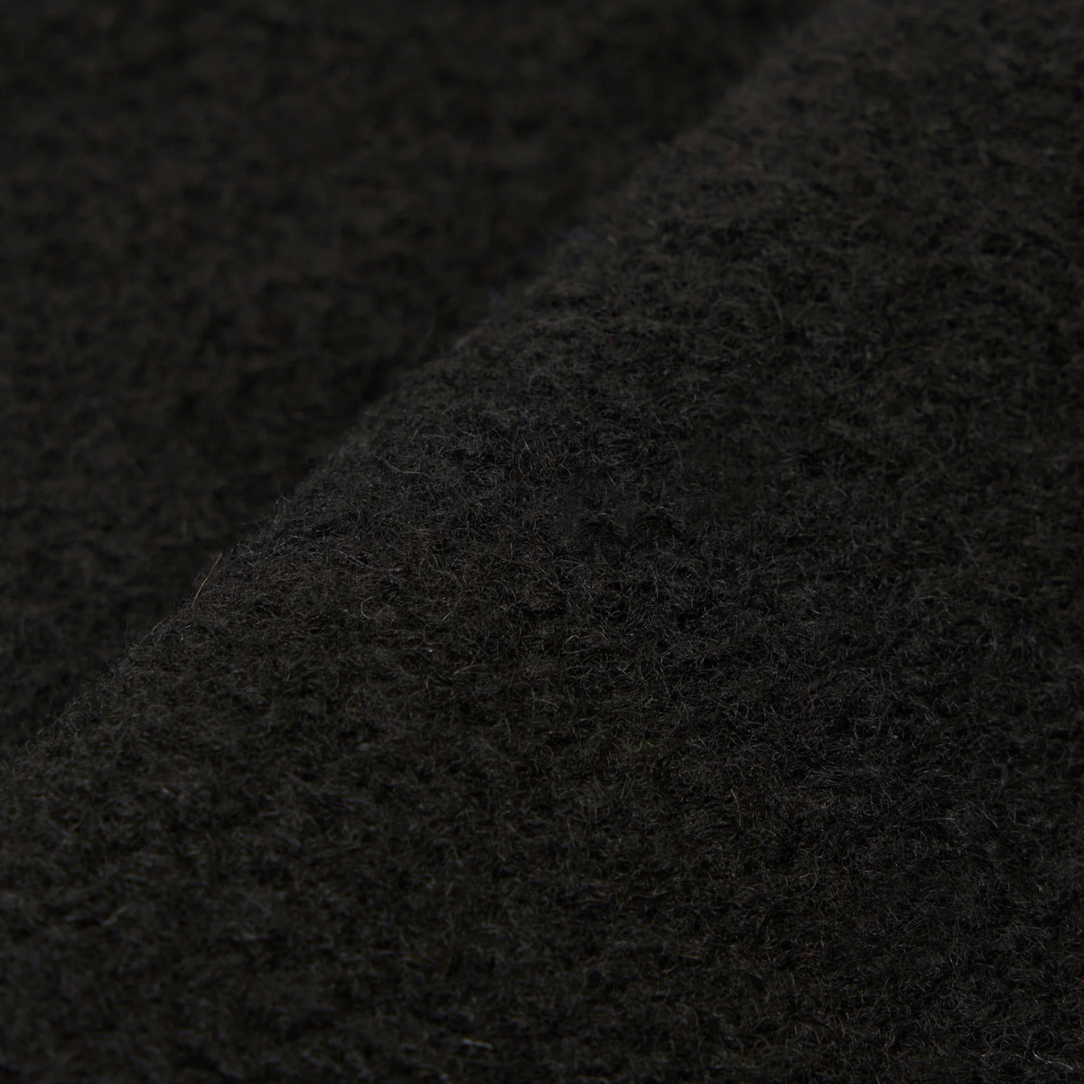 Gros plan du Wool Fleece noir du cardigan Universal Works, surface duveteuse et bouclée